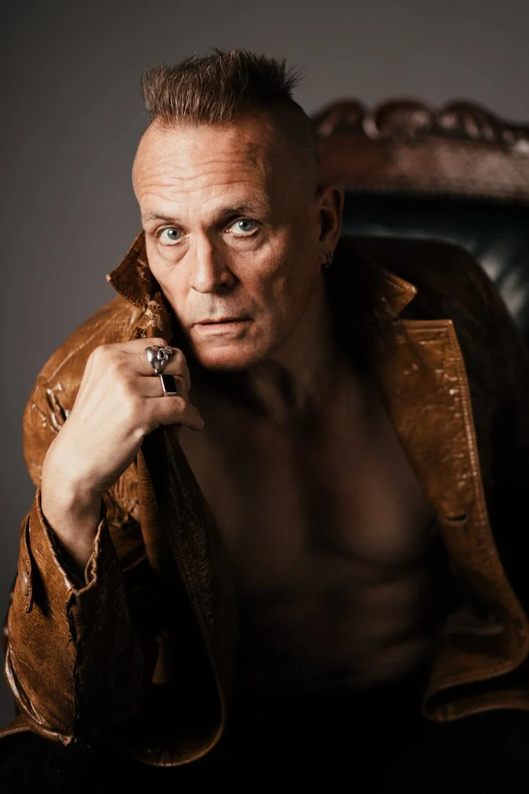 Portrait of John Robb the noted writer and music journalist based in manchester. Creative portrait taken in a studio by Debbie Ellis