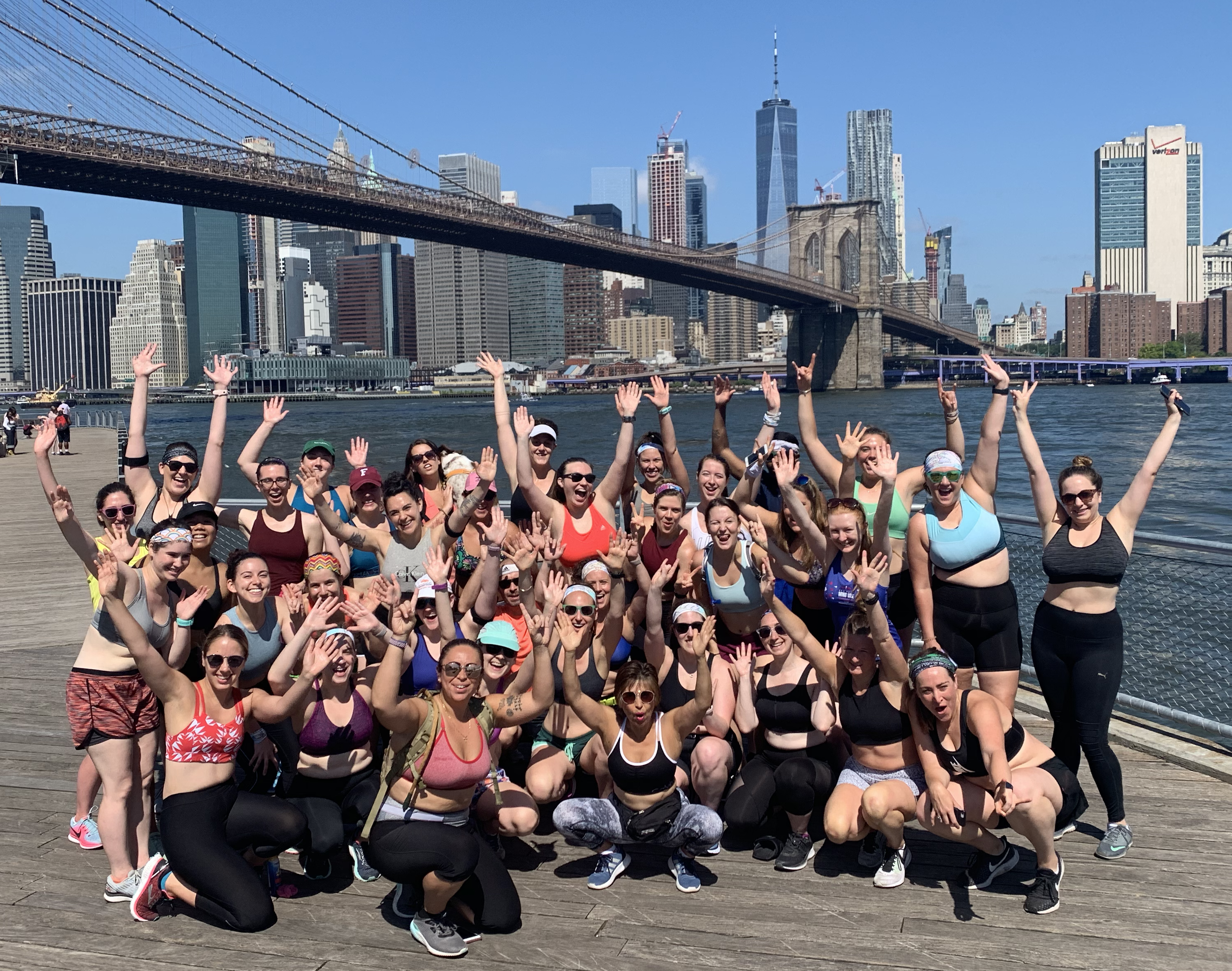 Group of women at badass lady gang running club with hands in the air