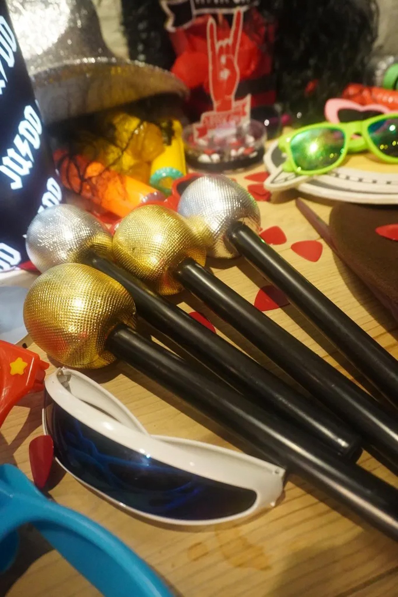 Assorted props including toy microphones, sunglasses, and novelty items on a table.