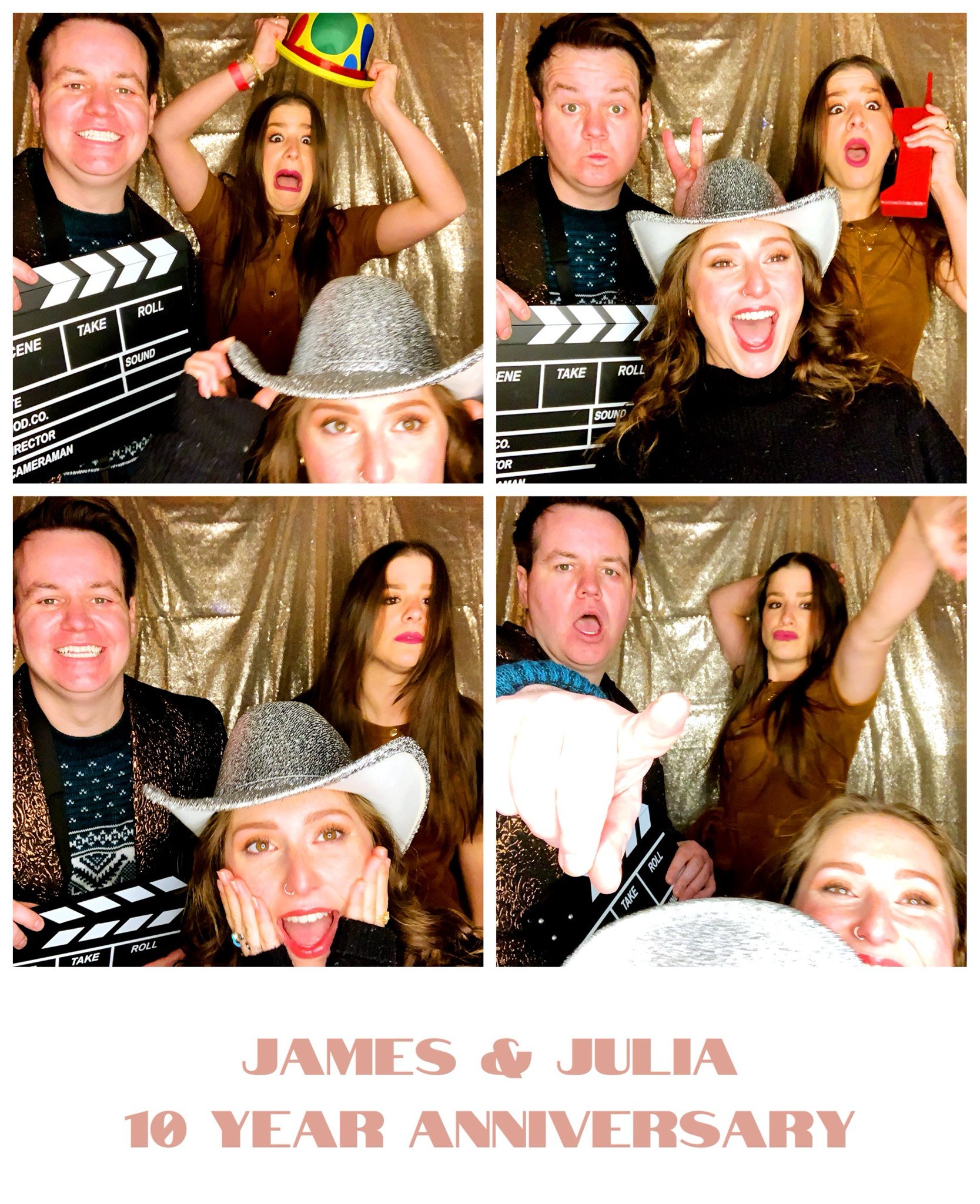 Three people posing in a photo booth with film clapboards and playful expressions. They are celebrating "James & Julia 10 Year Anniversary" with various props like a hat and drink container against a shiny backdrop.