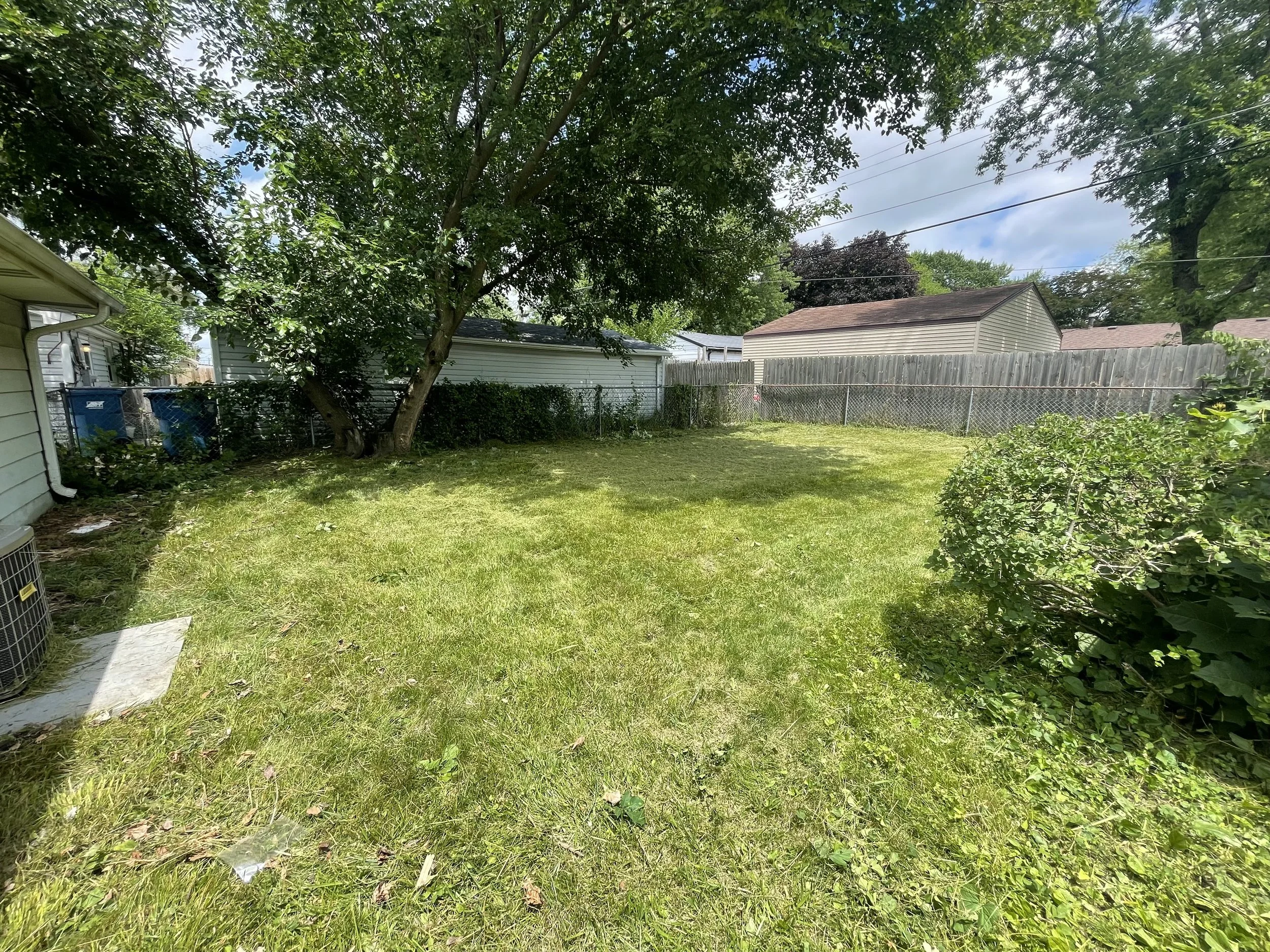 After: The same Bourbonnais backyard after overgrown lawn cleanup by The Lawn Care Company.