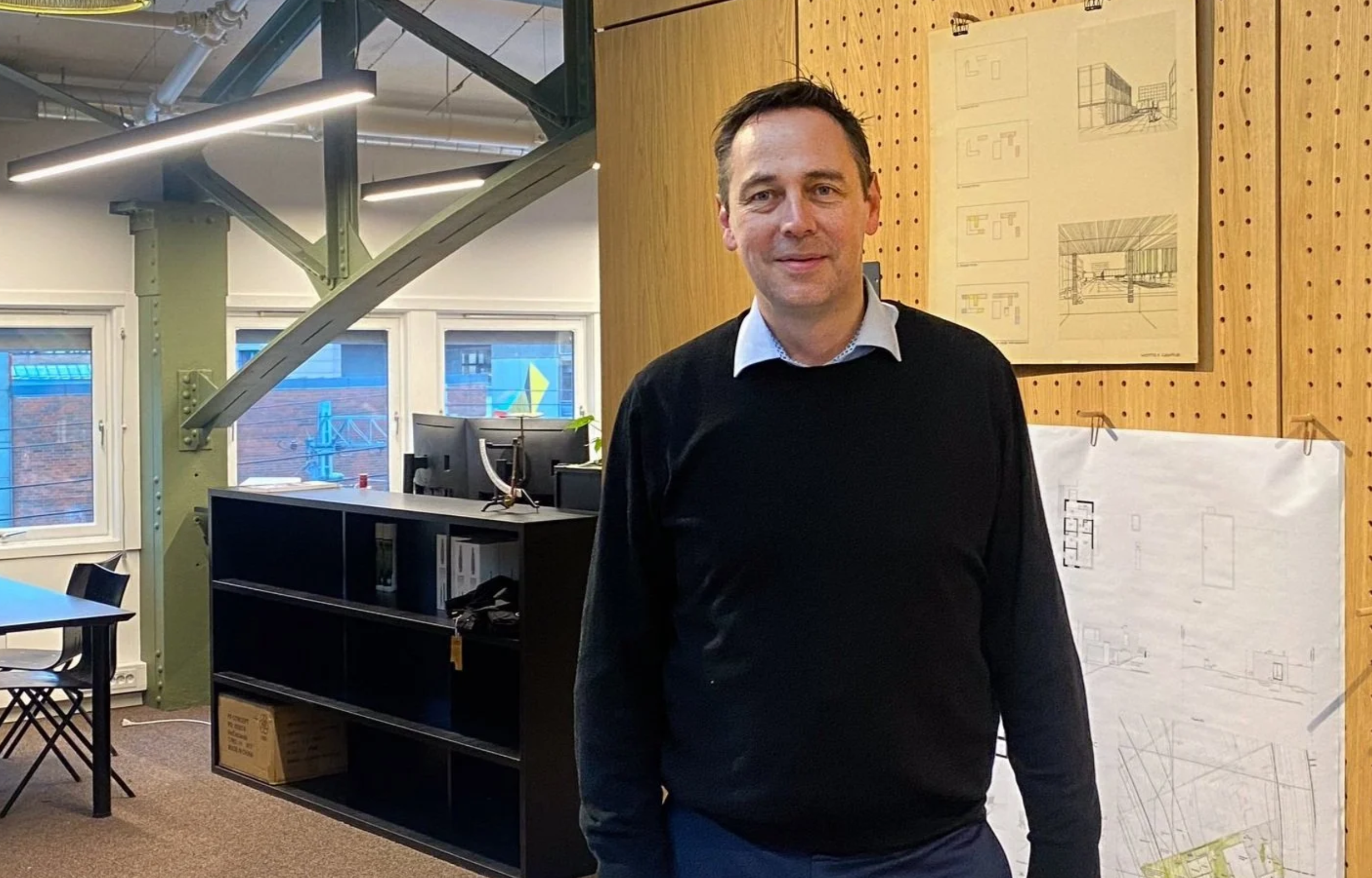 Mann som jobber som arkitekt sammen med tegninger