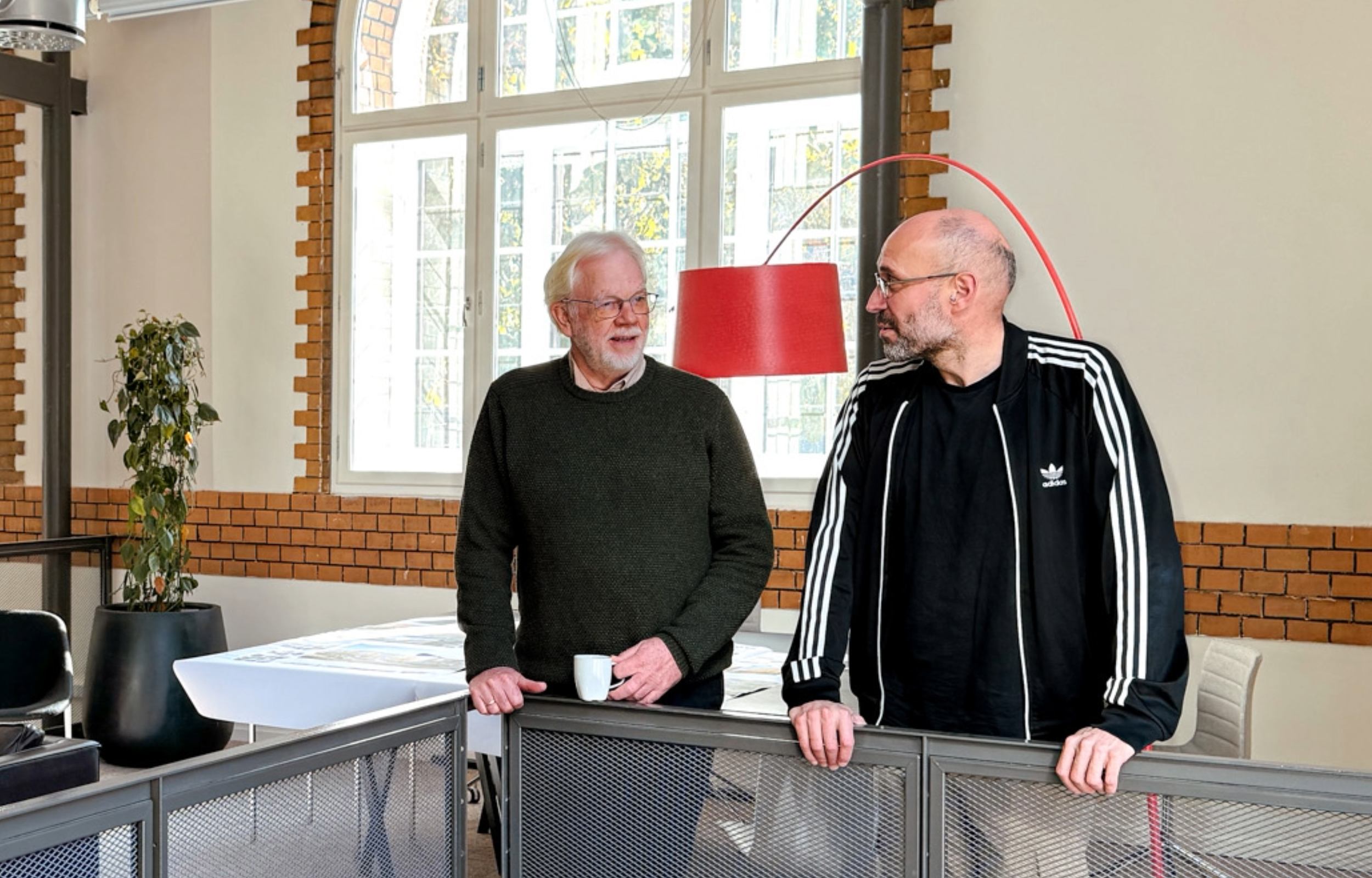 2 menn som snakker sammen på et arkitektkontor