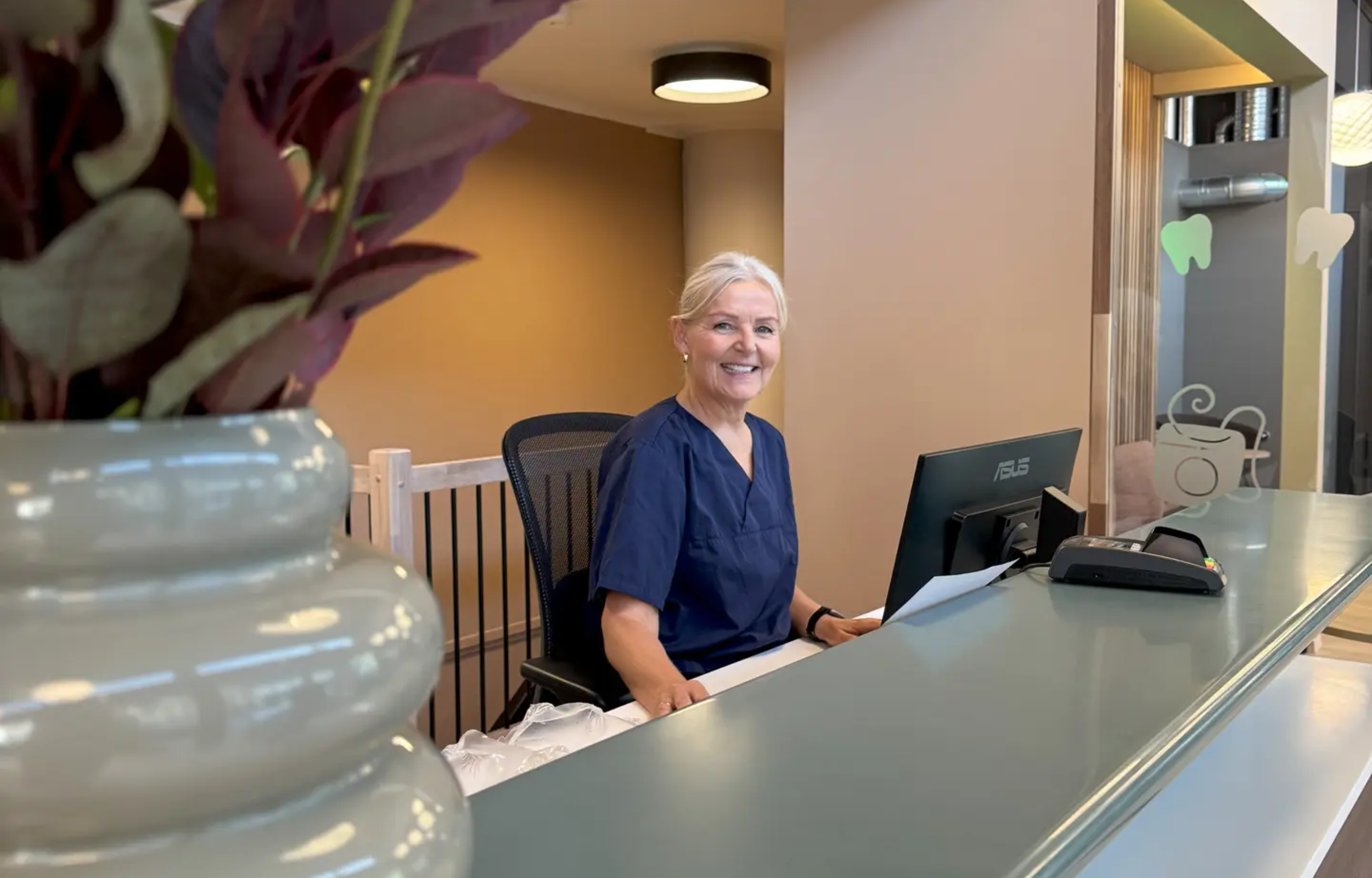 Ty tannklinikk resepsjonist foran dataskjerm levert av Garnes data som IT leverandør for tannklinikken
