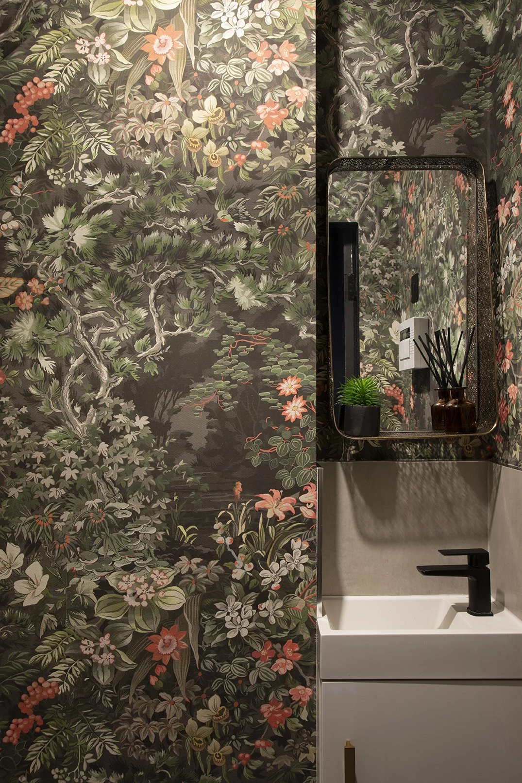 Downstairs cloakroom with dramatic dark botanical wallpaper, white wall-mounted basin, black square tap and brass framed mirror, Lytham Road Tynemouth