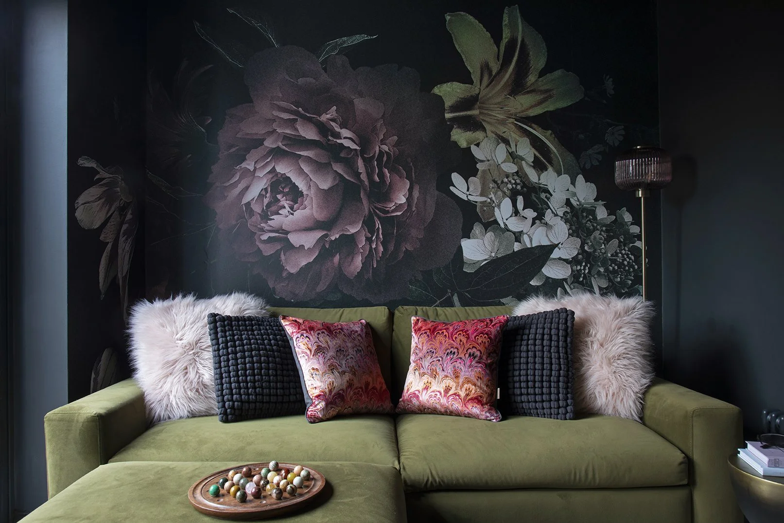 Olive green velvet sofa with mixed cushions in front of dramatic dark botanical peony mural, hidden snug, Lytham Road Whitley Bay
