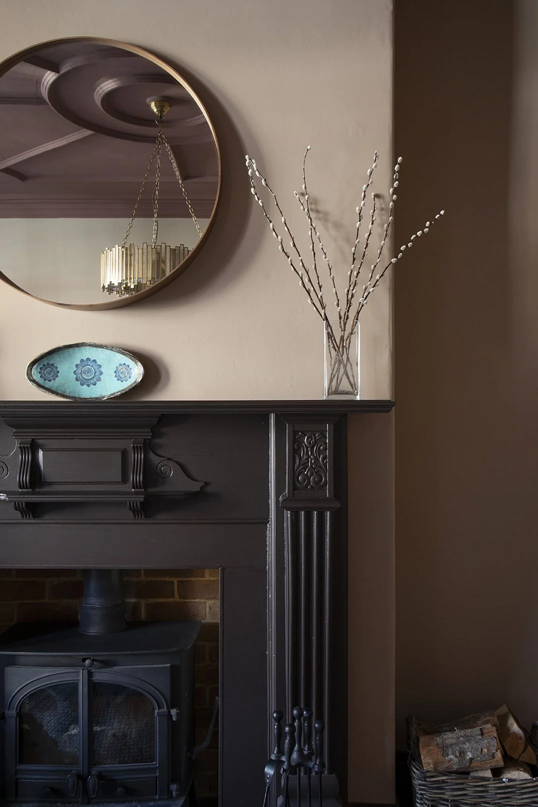 Close-up detail of the Victorian fireplace in the sitting room of the Queens Road project by Carole Crowe Interior Design, Whitley Bay, painted in deep charcoal with ornate carved corbels and column detailing, housing a cast iron wood-burning stove, 
