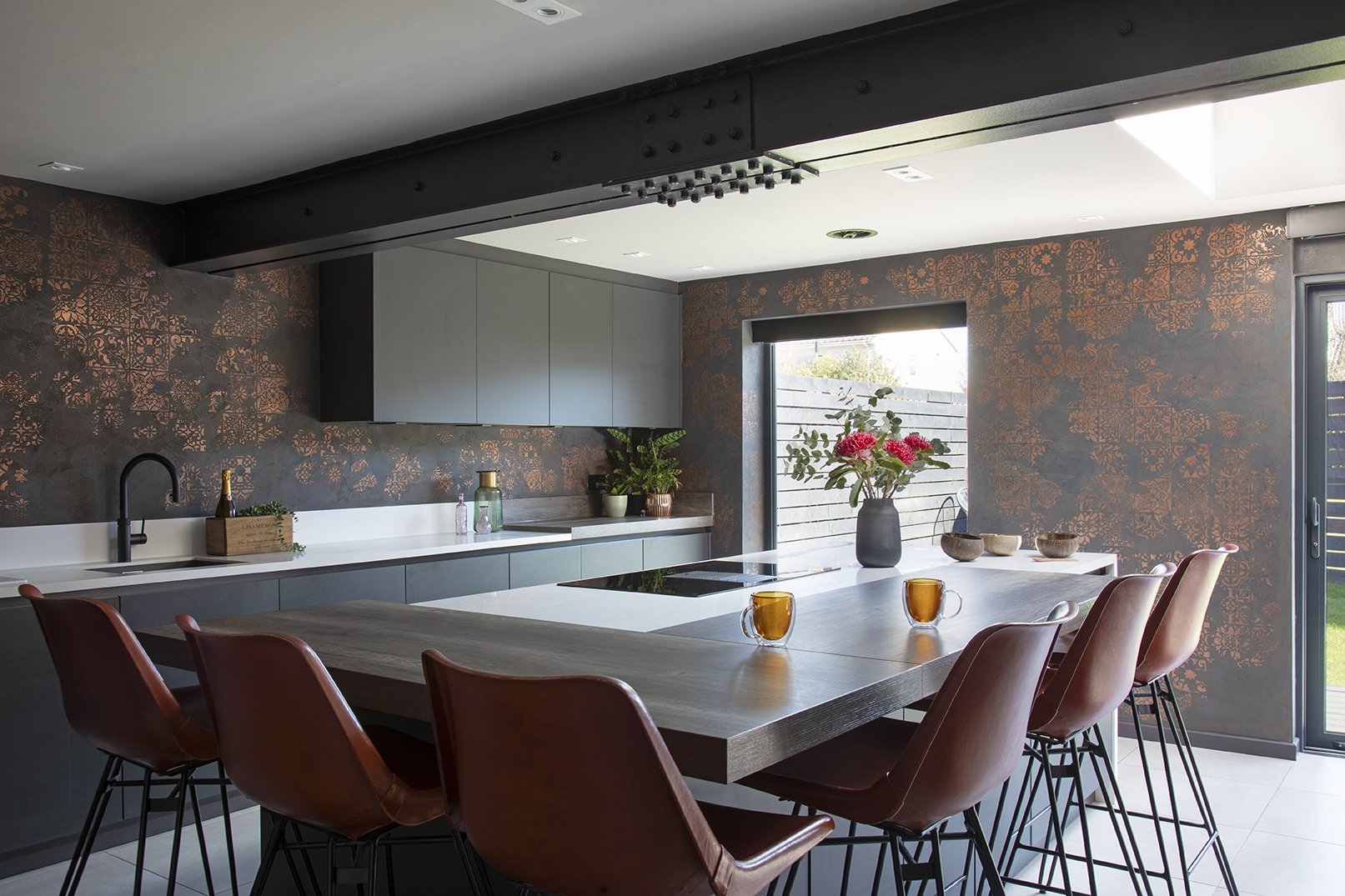 itchen island end view with dominant black and copper Venetian plaster feature wall, garden bifold door and tan leather bar stools, Lytham Road Tynemouth