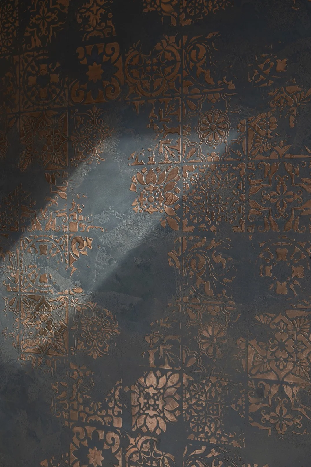Close-up detail of handcrafted black and copper Venetian plaster wall finish with ornate pattern, Lytham Road Tynemouth