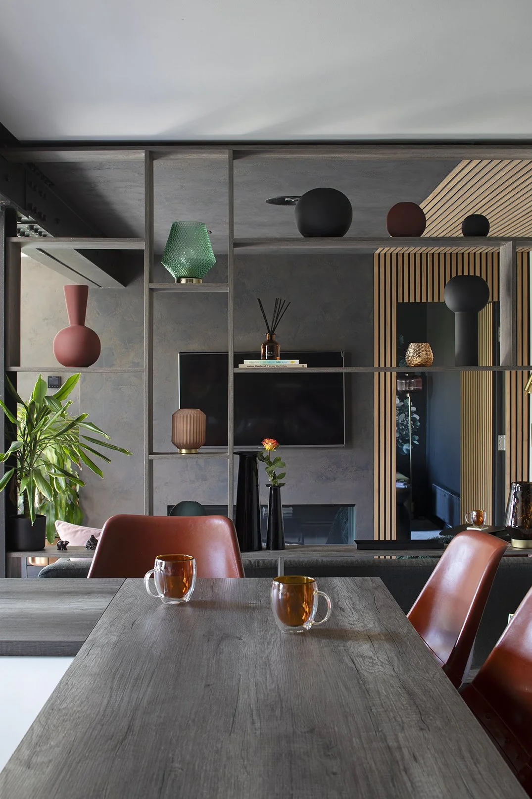 View from kitchen island bar across bespoke open shelving unit styled with ceramics, looking through to snug and living zones, Lytham Road Whitley Bay