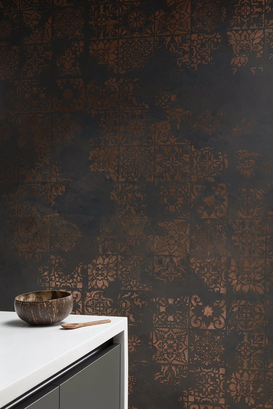 Black and copper Venetian plaster feature wall beside white kitchen worktop with coconut bowl styling detail, Whitley Bay interior design