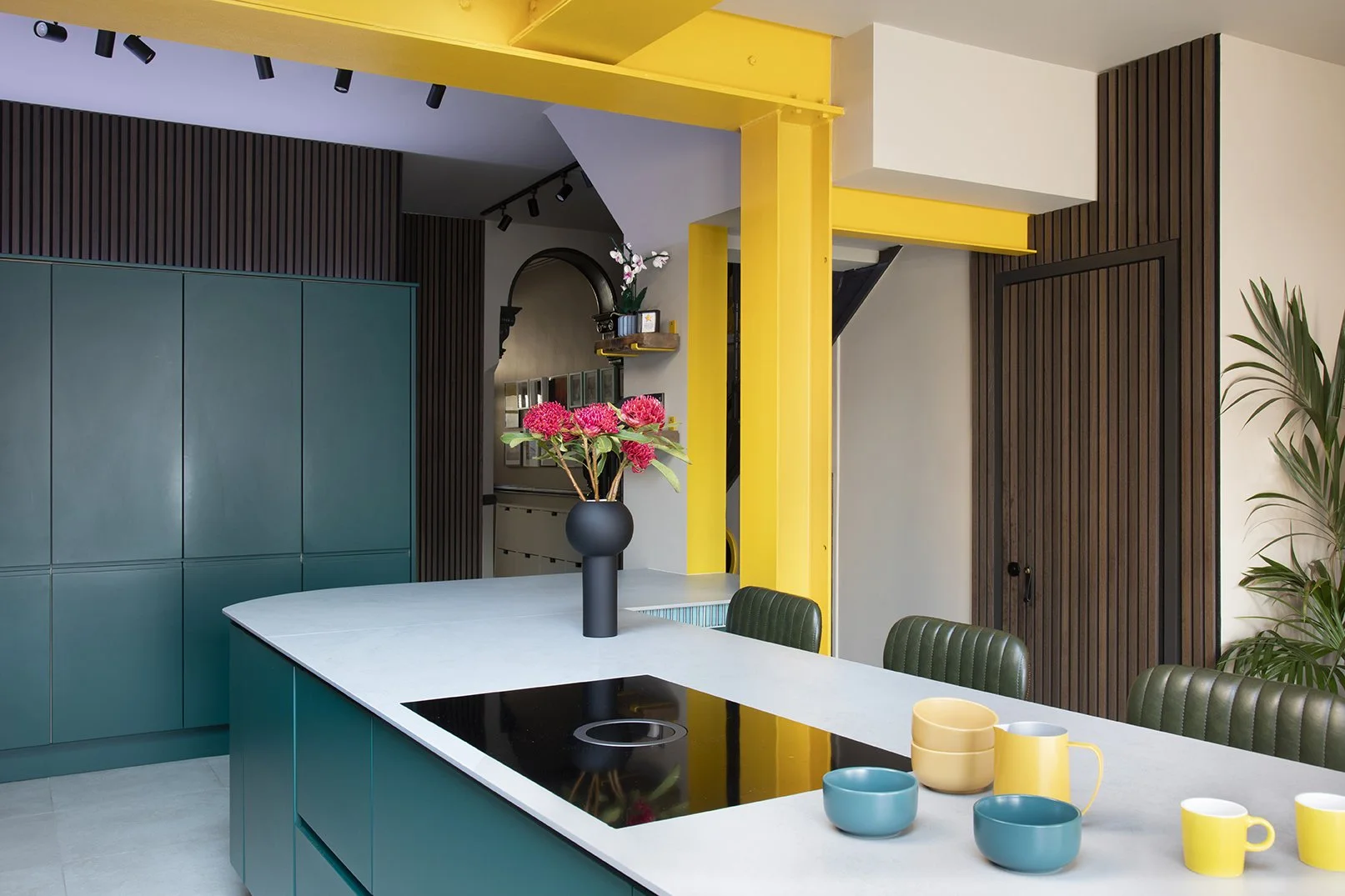 Bold family kitchen designed by Carole Crowe Interior Design in North Shields, featuring floor-to-ceiling teal handleless cabinetry, a curved kitchen island clad in vertical teal glazed tiles with a grey stone worktop, a painted yellow structural ste