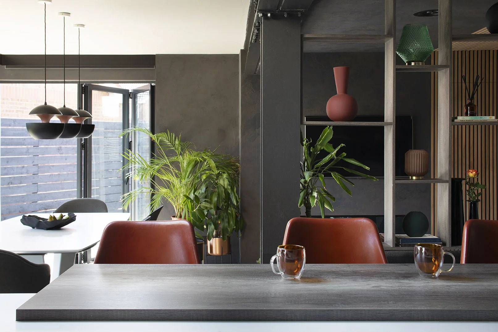 Kitchen island bar with tan leather bar stools, open plan extension with copper pendant lights, tropical plants and bespoke shelving, Lytham Road Tynemouth