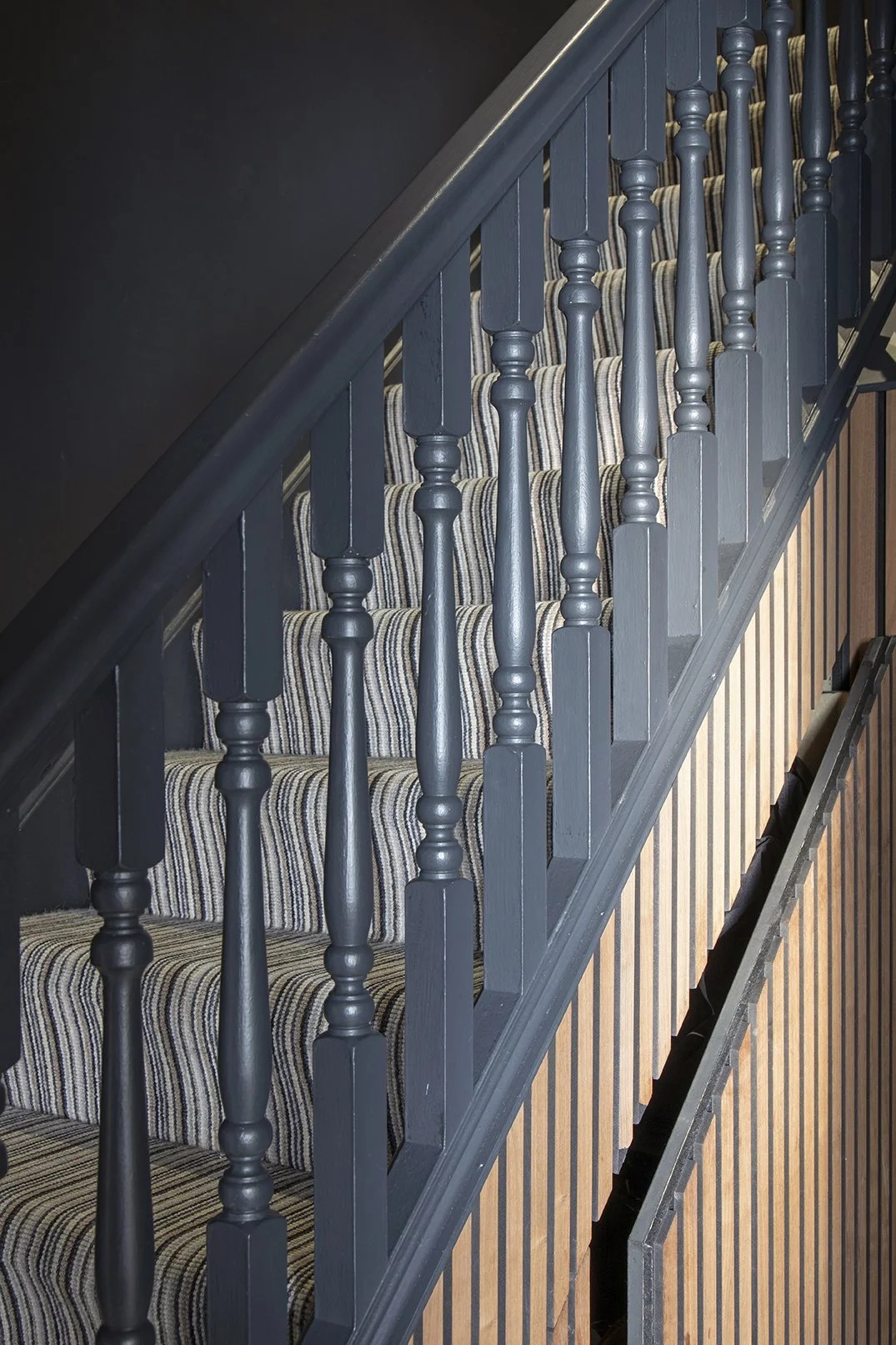 Painted Black staircase balustrade with striped stair runner and oak slat cladding, Lytham Road Tynemouth interior design under stair storage