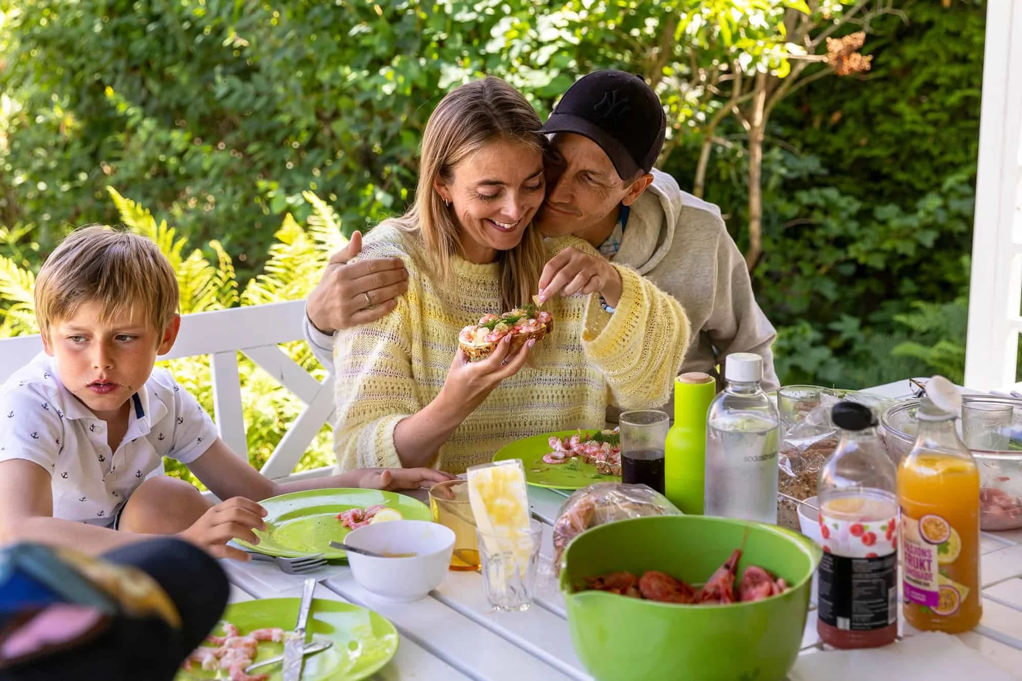 Familie samles rundt bordet til sommermåltid på hytta