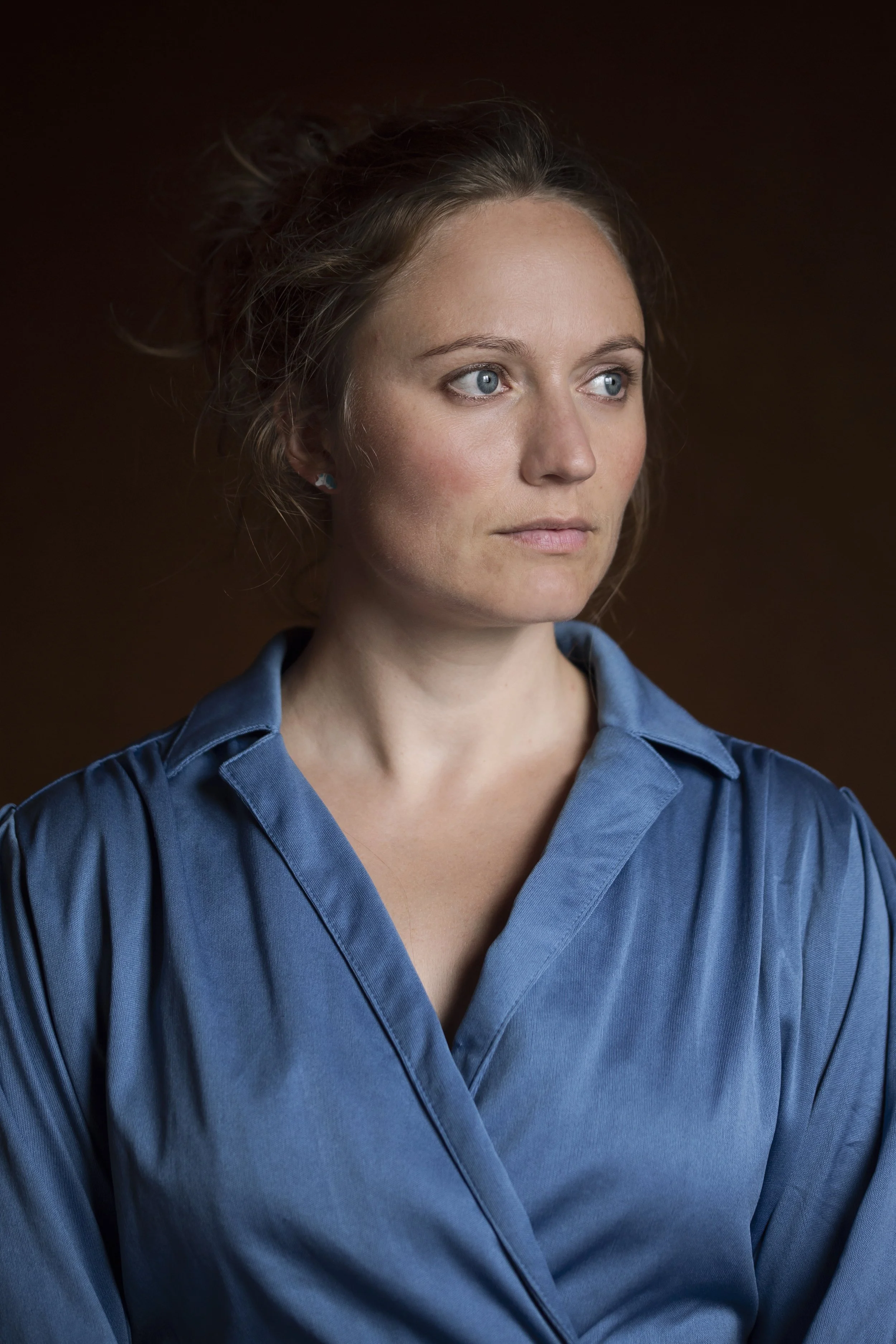 Alvorlig kvinne ikledd en blå kjole ser til siden