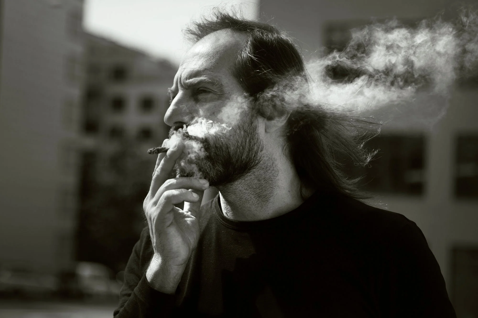 Musikeren Chango Spasiuk står og røyker i et bymiljø i Oslo