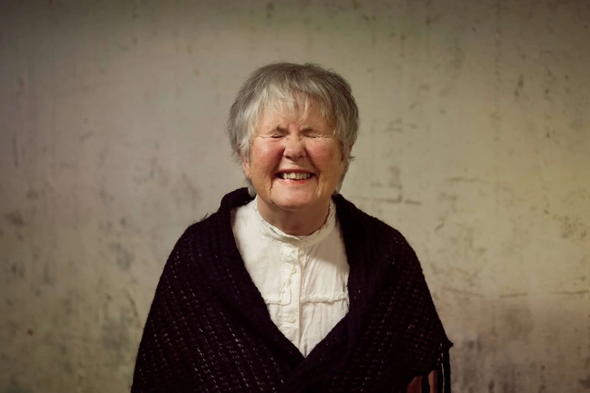 Portrett av en eldre kvinne som ler hjertelig