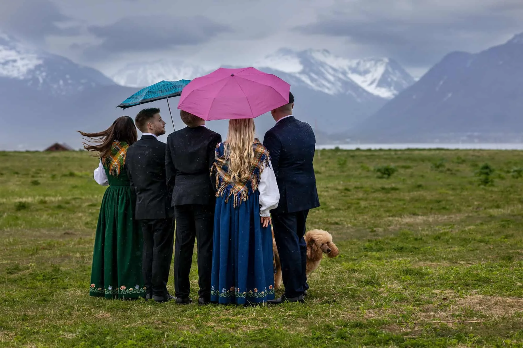 Konfirmantfotografering i regn med paraplyer ute i naturlig lys