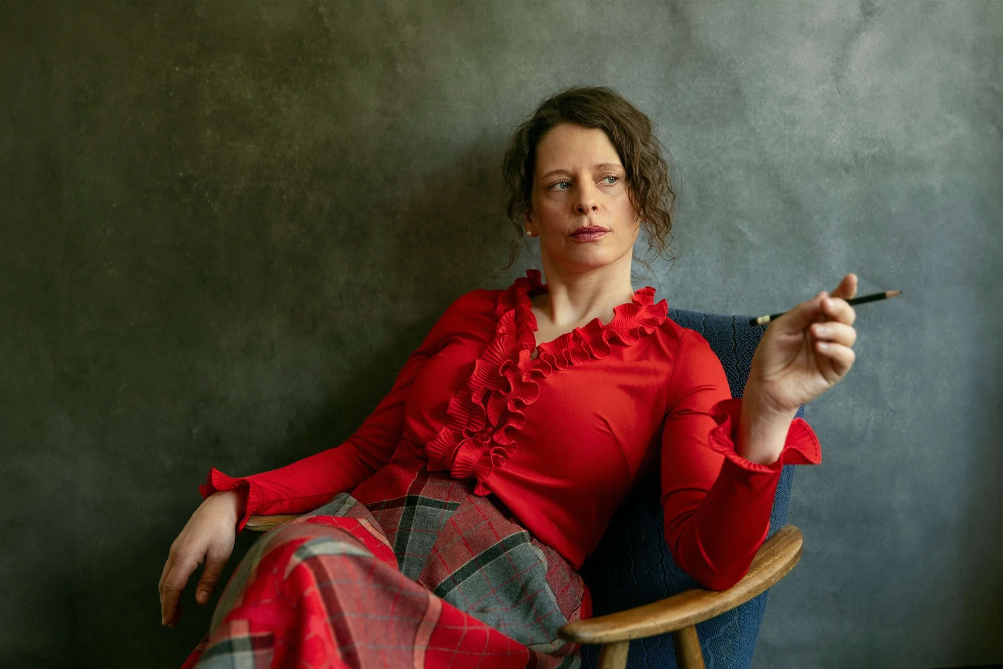 Portrett av skuespiller sittende i lenestol med blyant i hånden på kontor i Oslo.