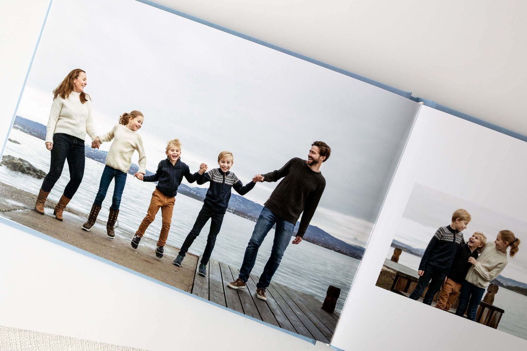 Innsiden av et fotoalbum med bilder av en familie som holder hender