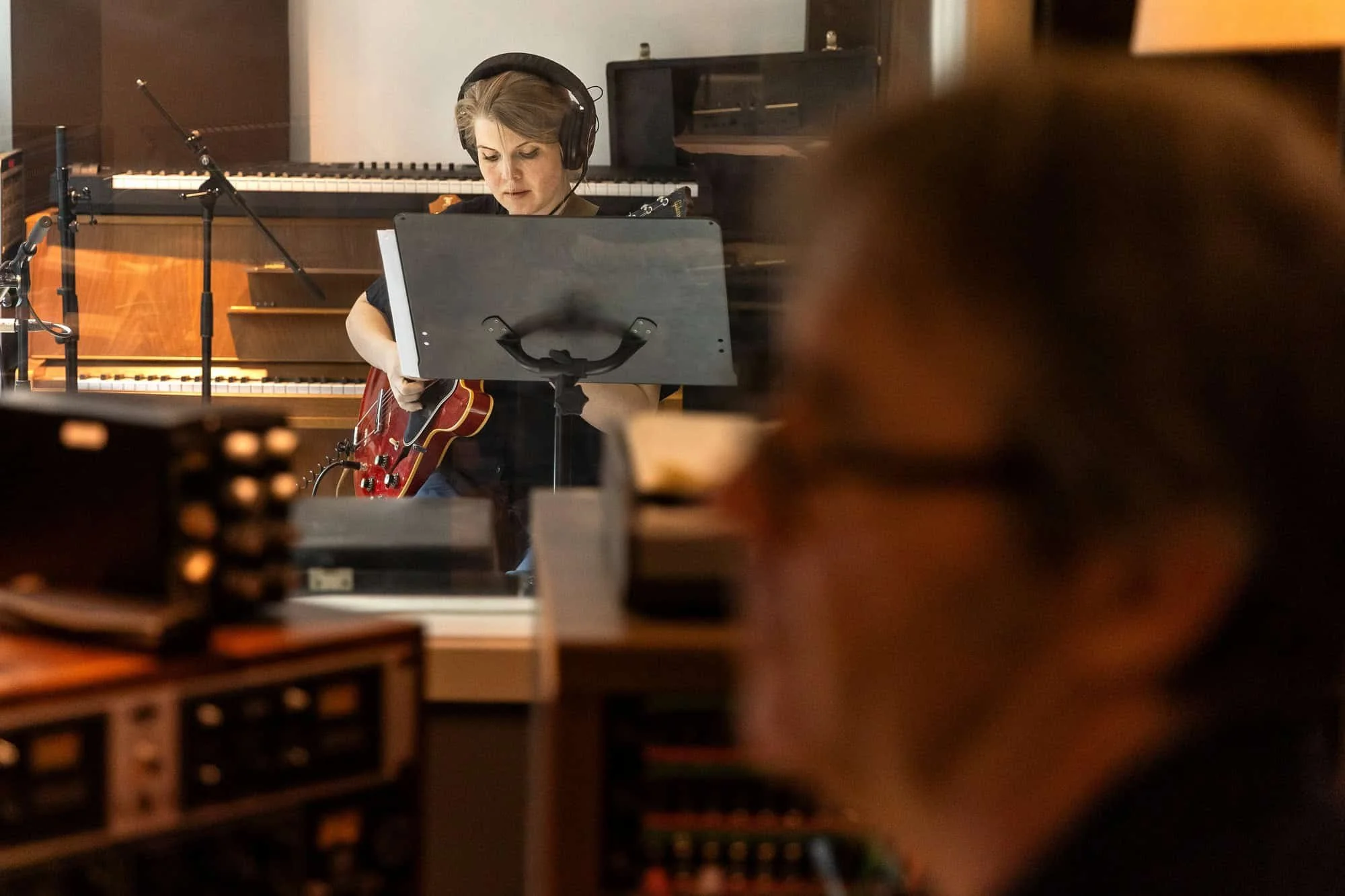 El-gitarist jobber konsentrert ved notestativ under innspilling i studio