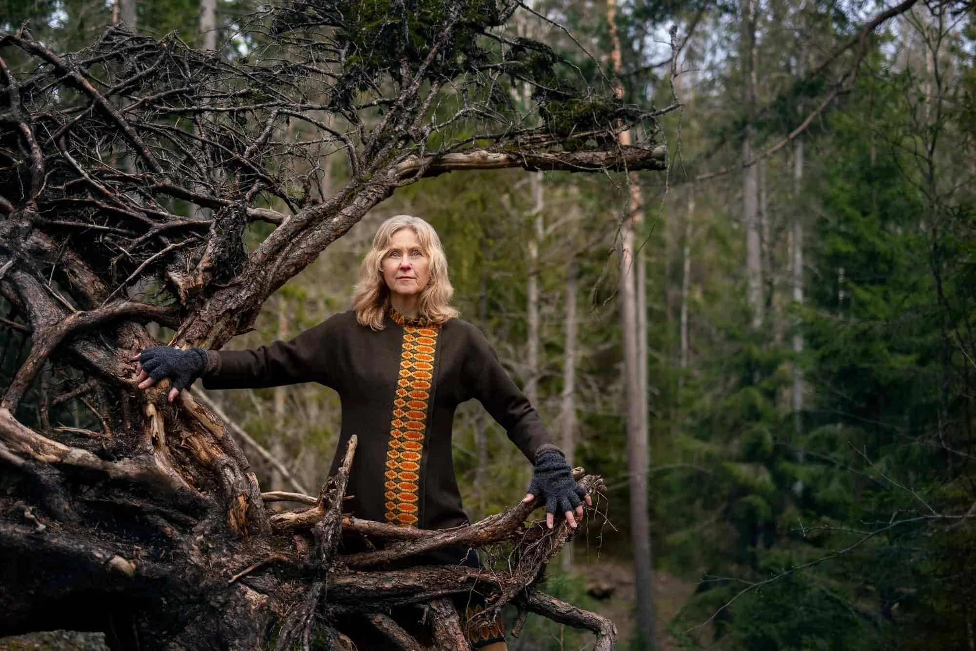 Kunstnerisk portrett av eldre kvinne i sterk positur i skogen