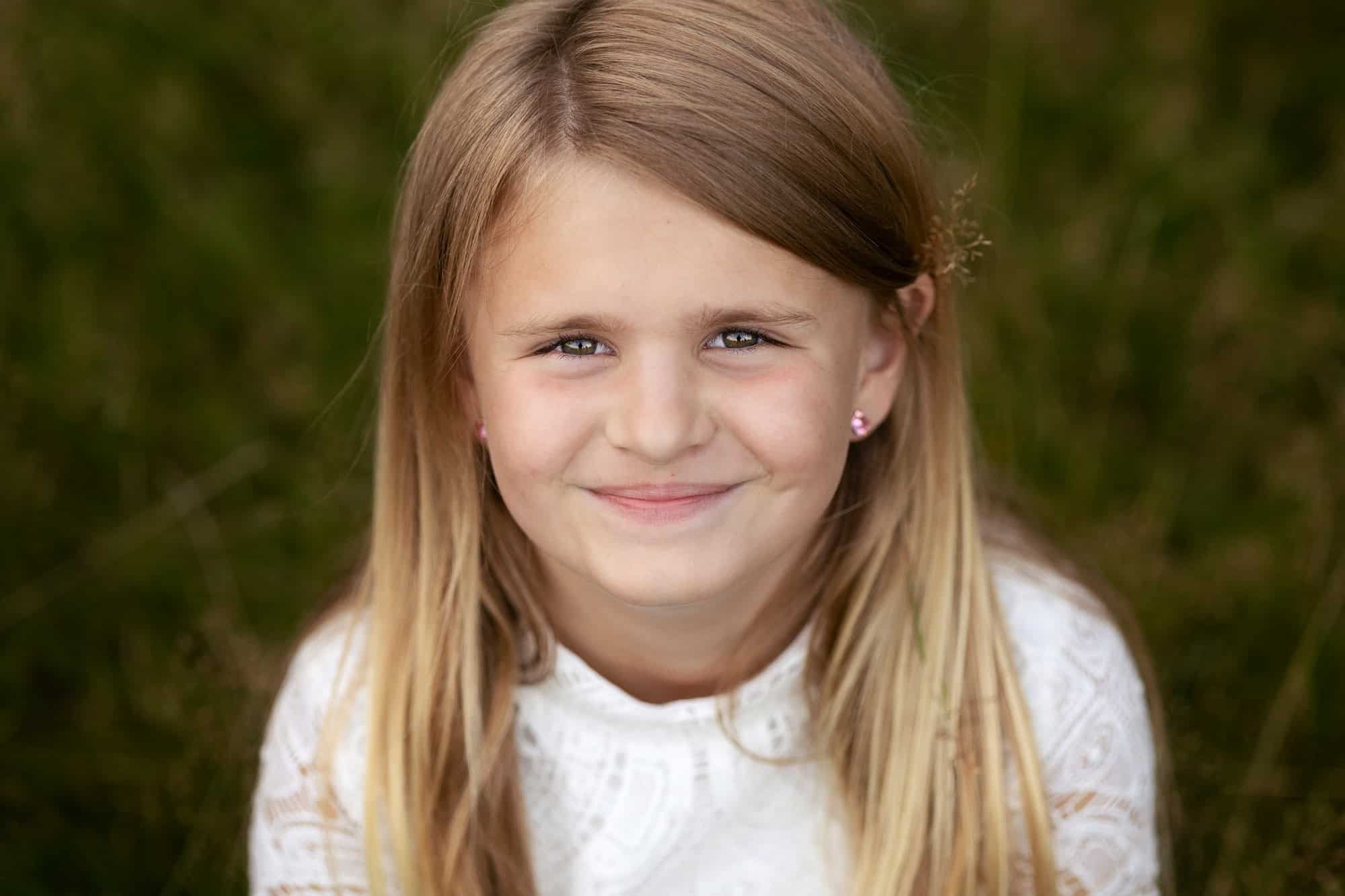 Smilende jente mot mørk og dus bakgrunn