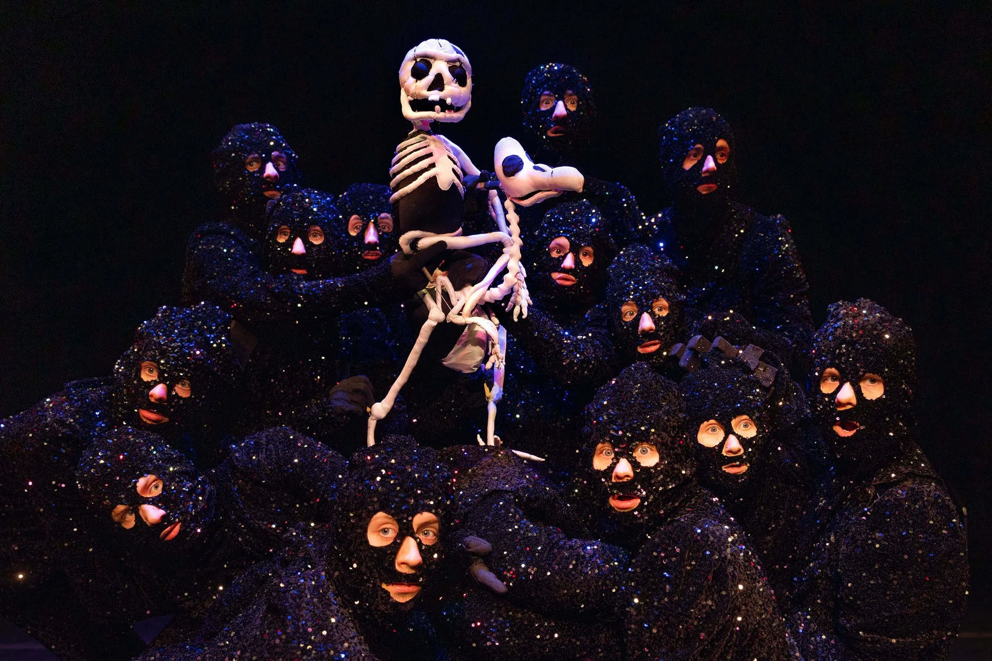 Scenebilde fra Dead as a Dodo av Wakka Wakka med ensemble rundt skjelettfigur i mørk scenografi.