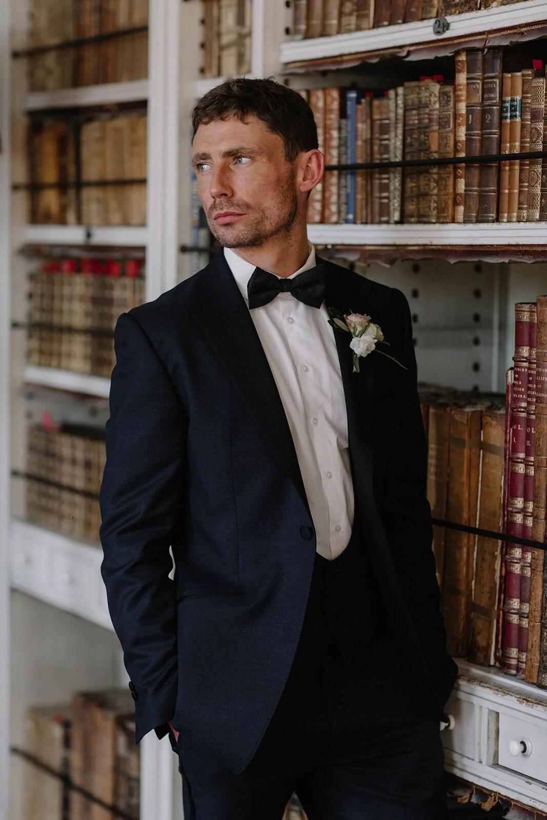 Male model Matt Sharman wears a blue tuxedo with white shirt and black bow tie at St Giles House in Dorset   
