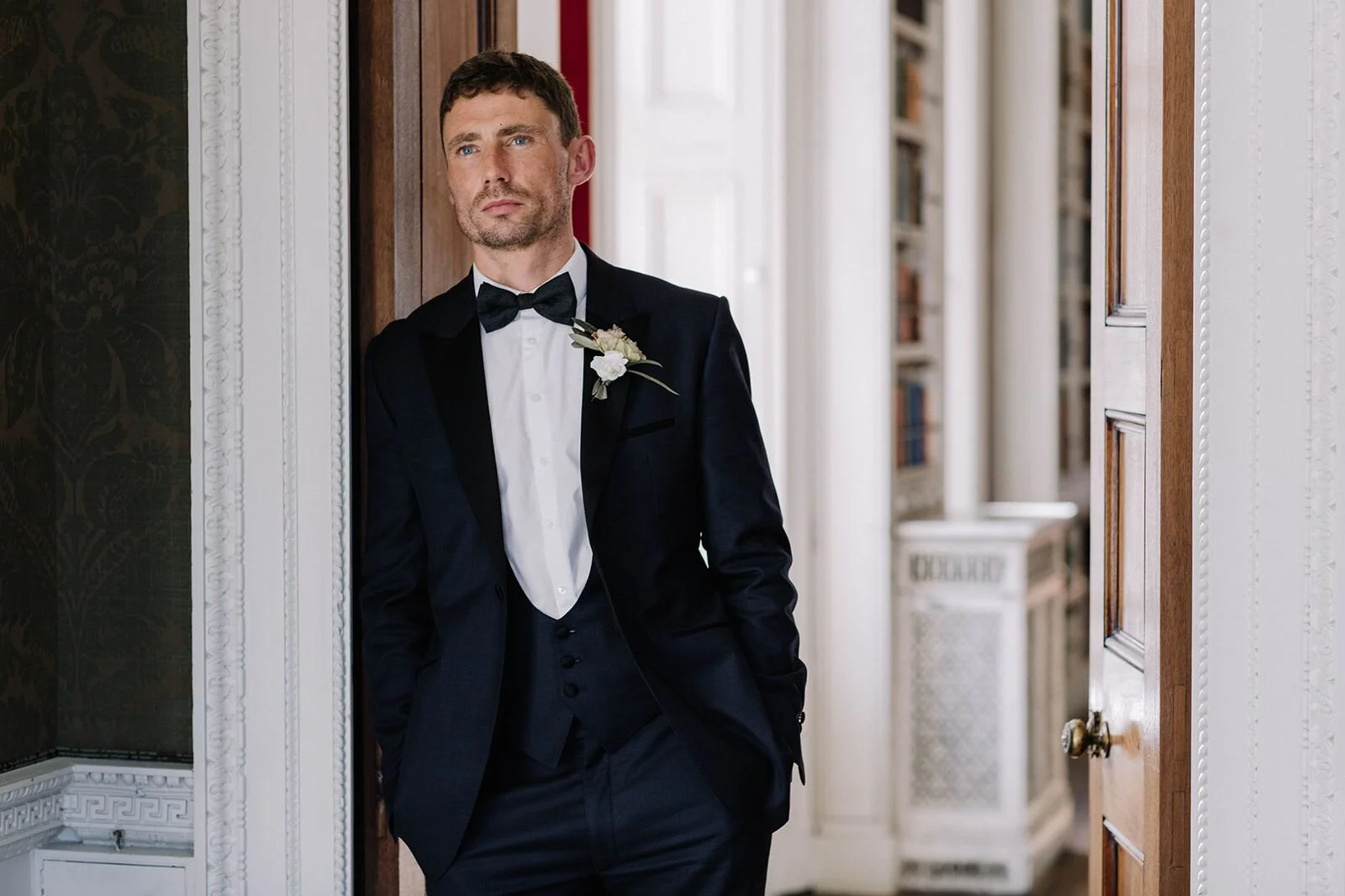Male model Matt Sharman wears a blue tuxedo with white shirt and black bow tie at St Giles House in Dorset   