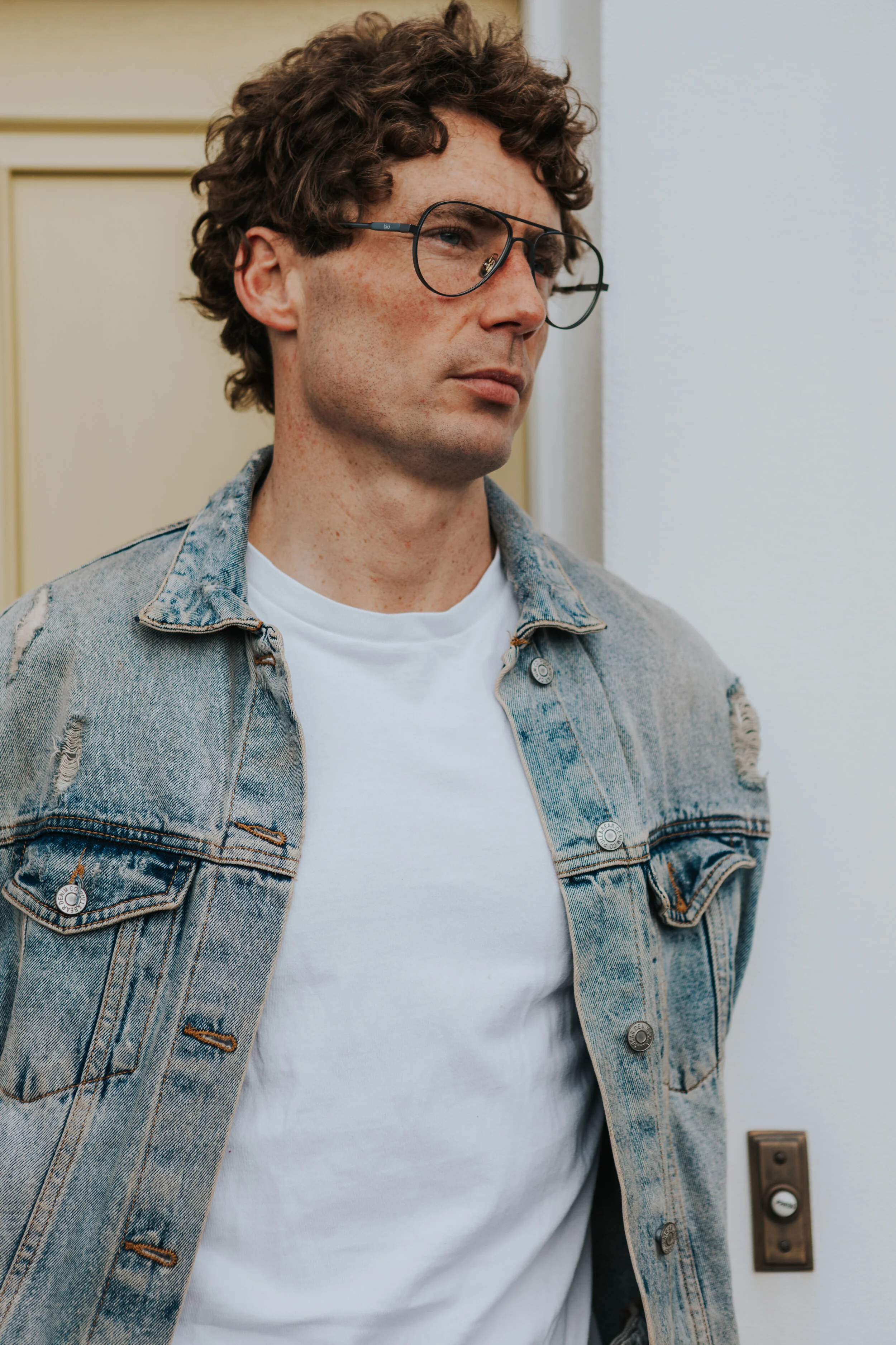 Male model Matt Sharman wears Bird Sunglasses and a jean jacket