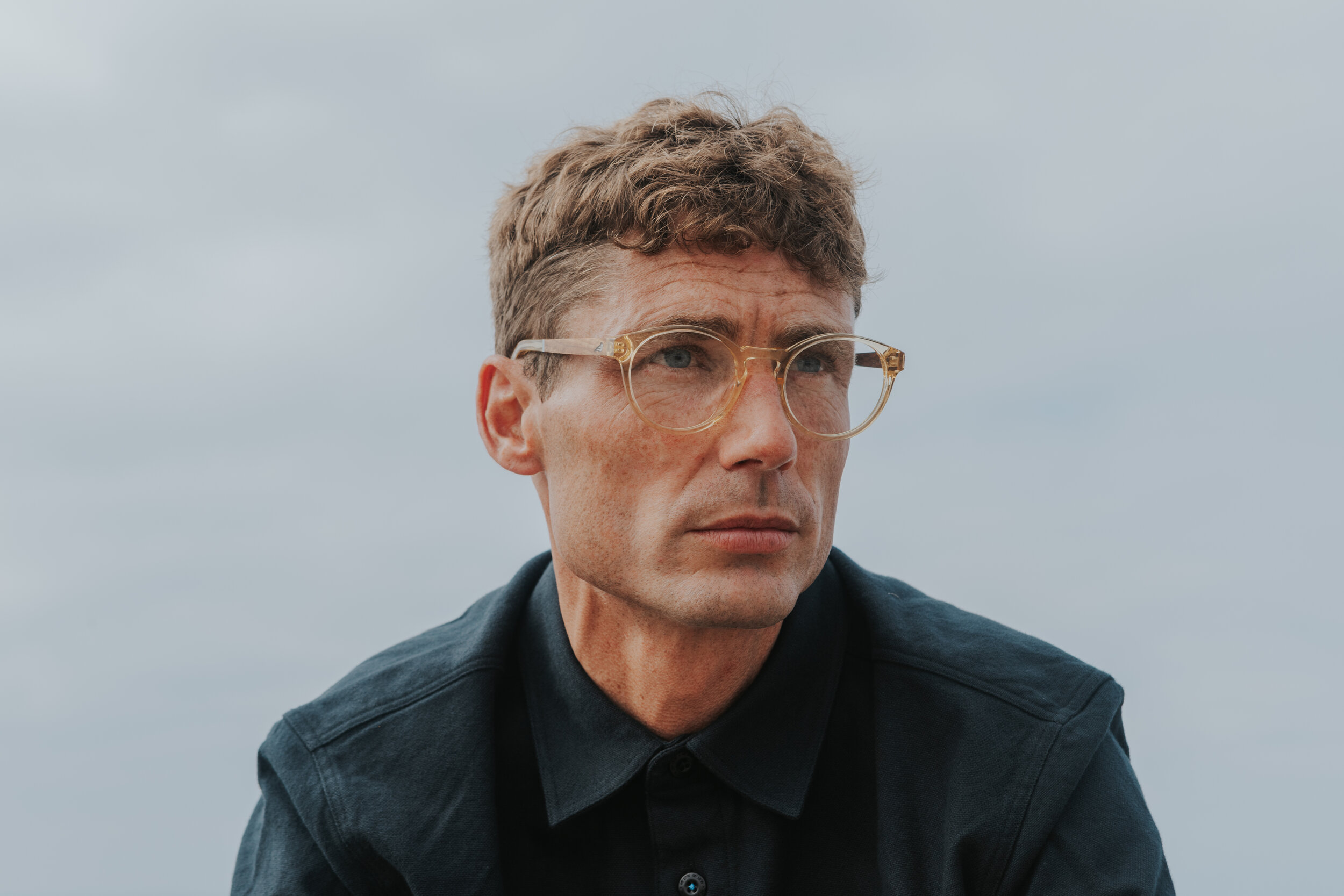 Male model Matt Sharman wears Bird Sunglasses and a blue shirt
