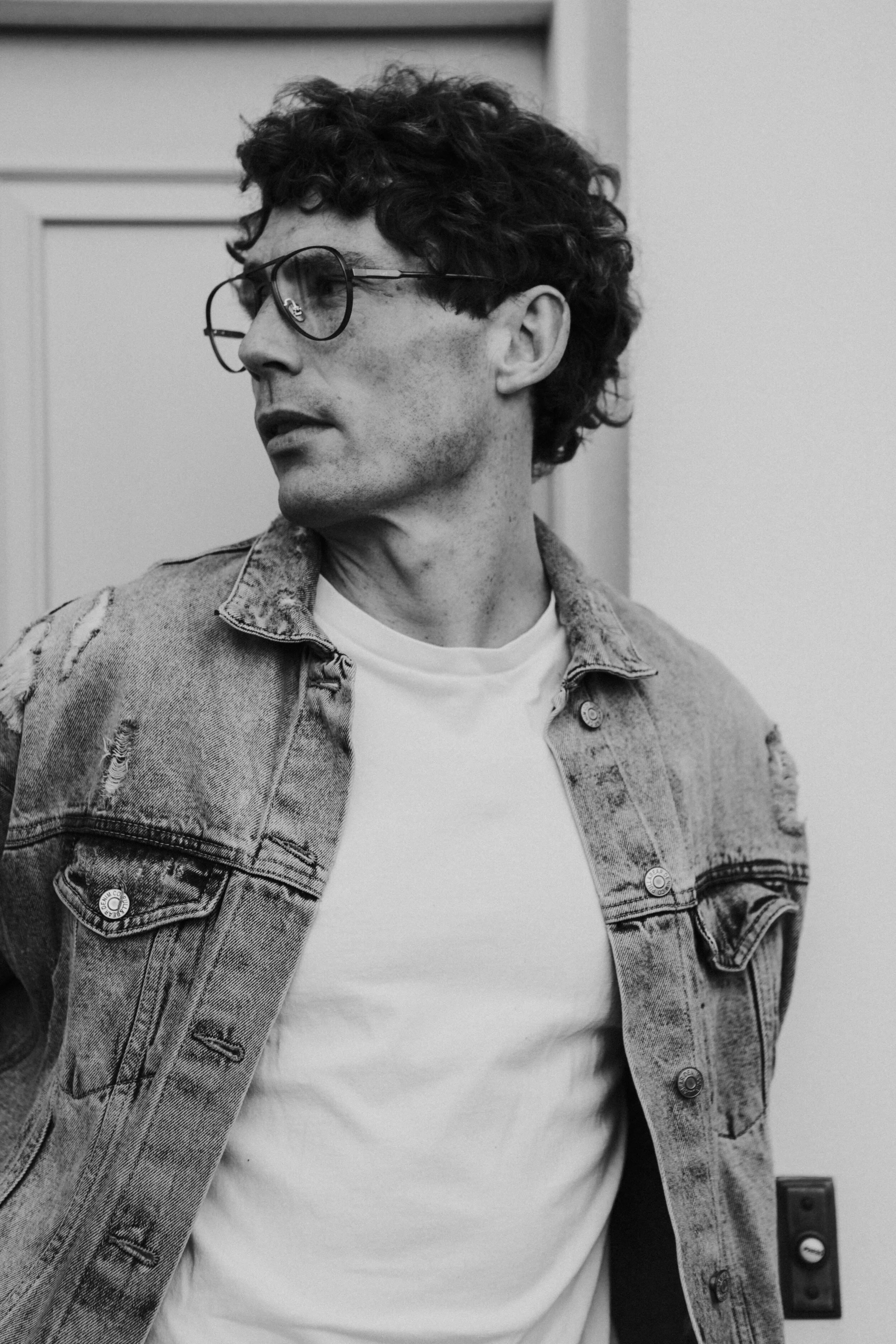 Male model Matt Sharman wears Bird Sunglasses and a jean jacket