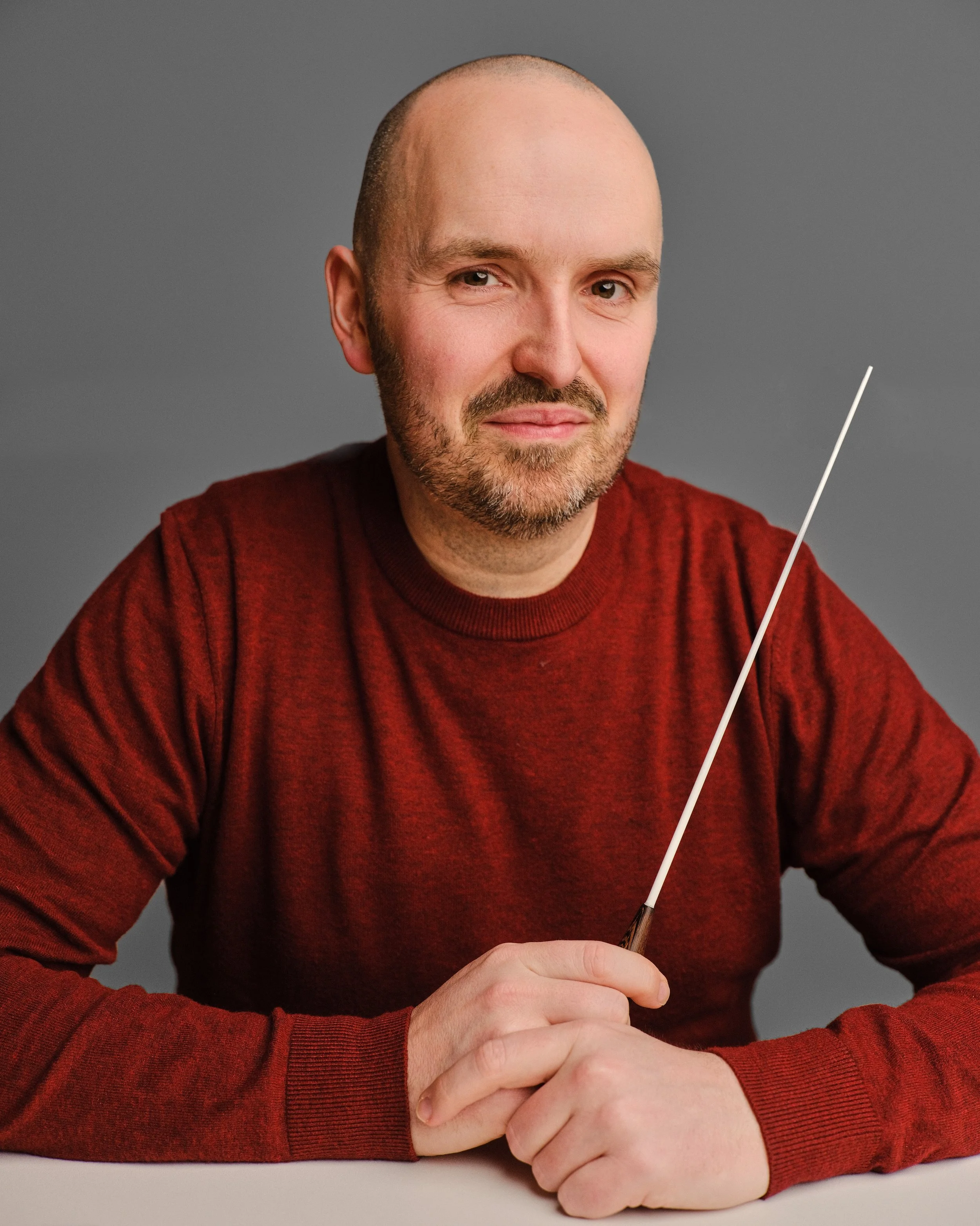 Paul Emmett, East Midlands composer, conductor and arranger, holding a conductors baton