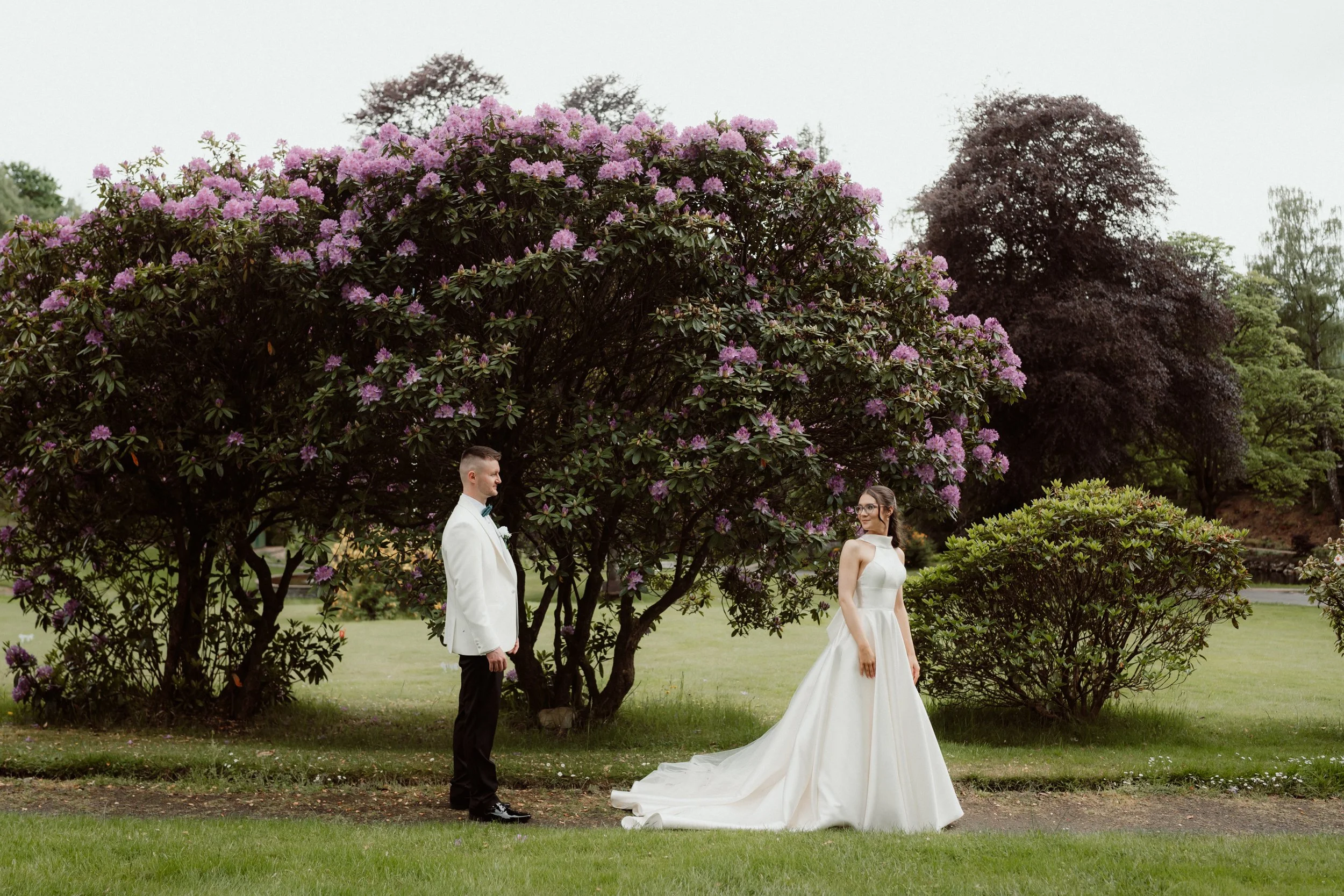 Bride and groom walking through the gardens at Atholl Palace Hotel wedding in Pitlochry.