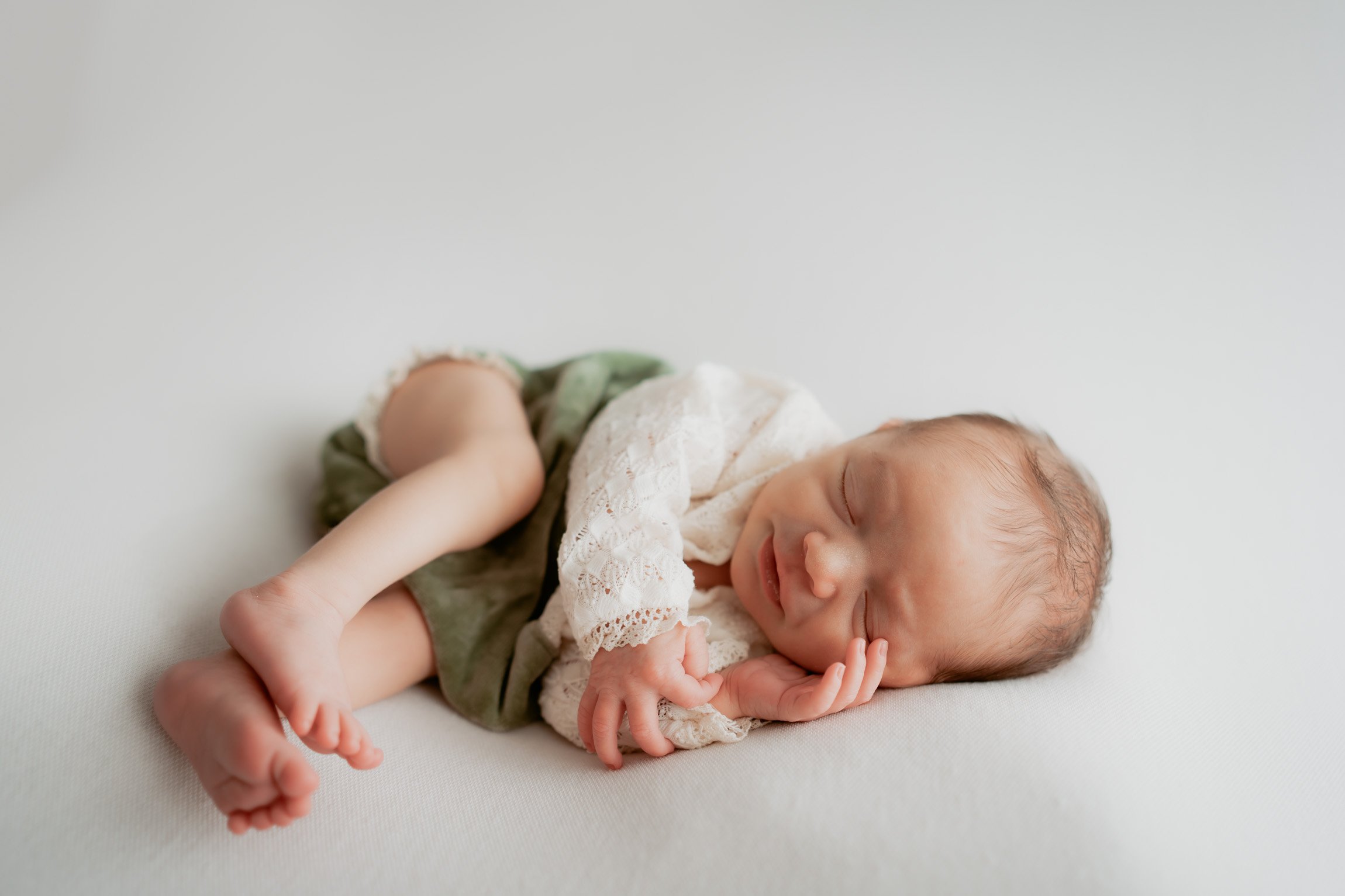 Curled up baby photoshoot pose
