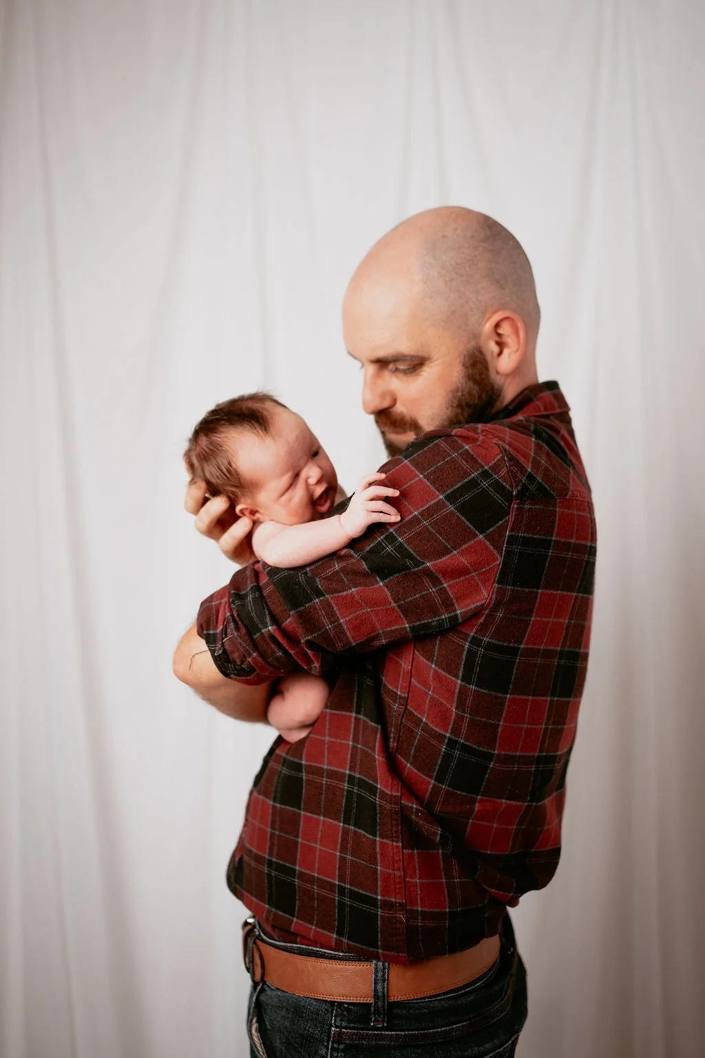 A father holding his newborn baby during a natural photoshoot in Perthshire, Scotland.