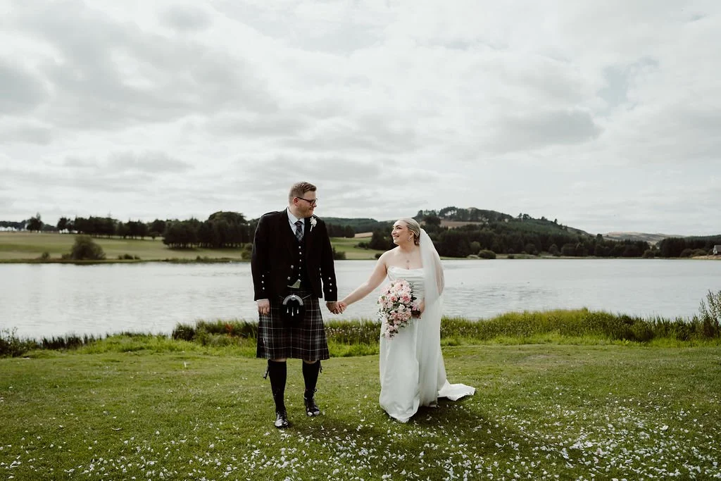 Ryan and Ashleigh walking together beside the water at Piperdam Resort