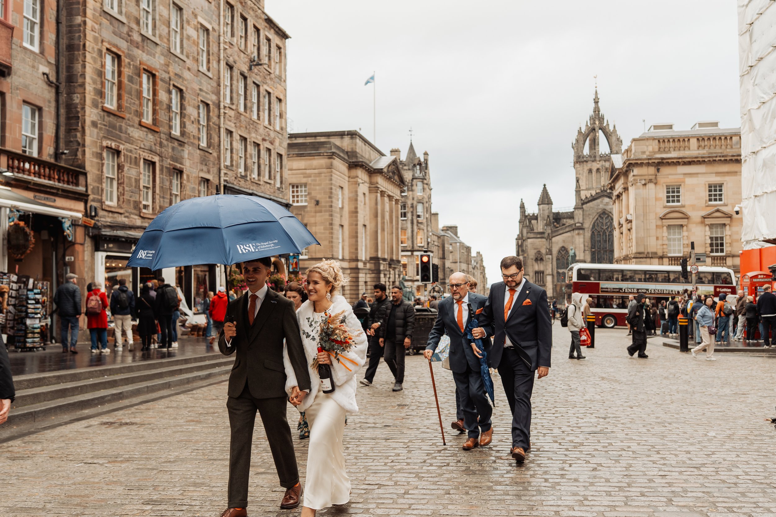 Newly married couple walking through Edinburgh streets after their ceremony