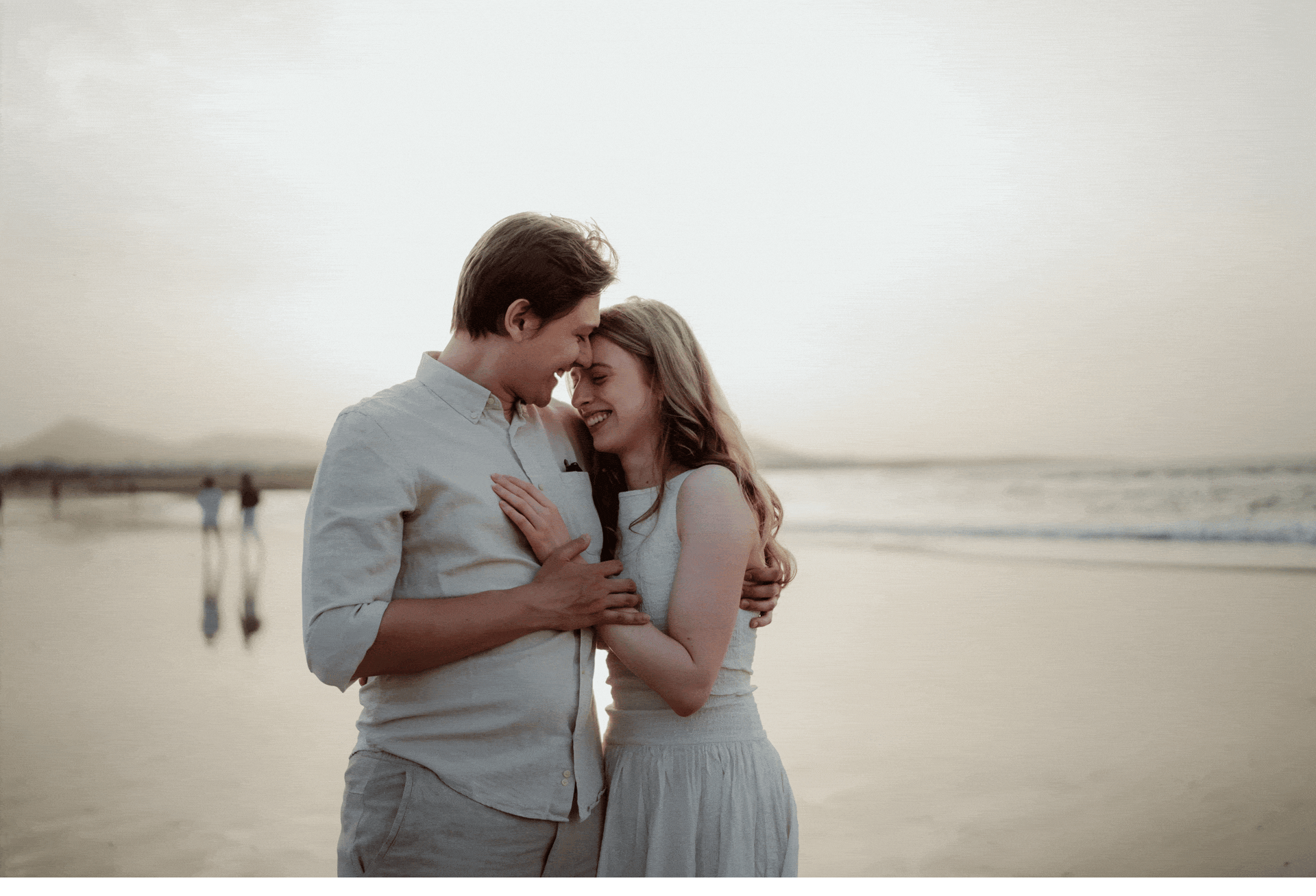 couple playing on the la famara beach in lanzarote, by scenic views, on dunes and in the sea wearing neutral tones clothes having romantic photoshoot