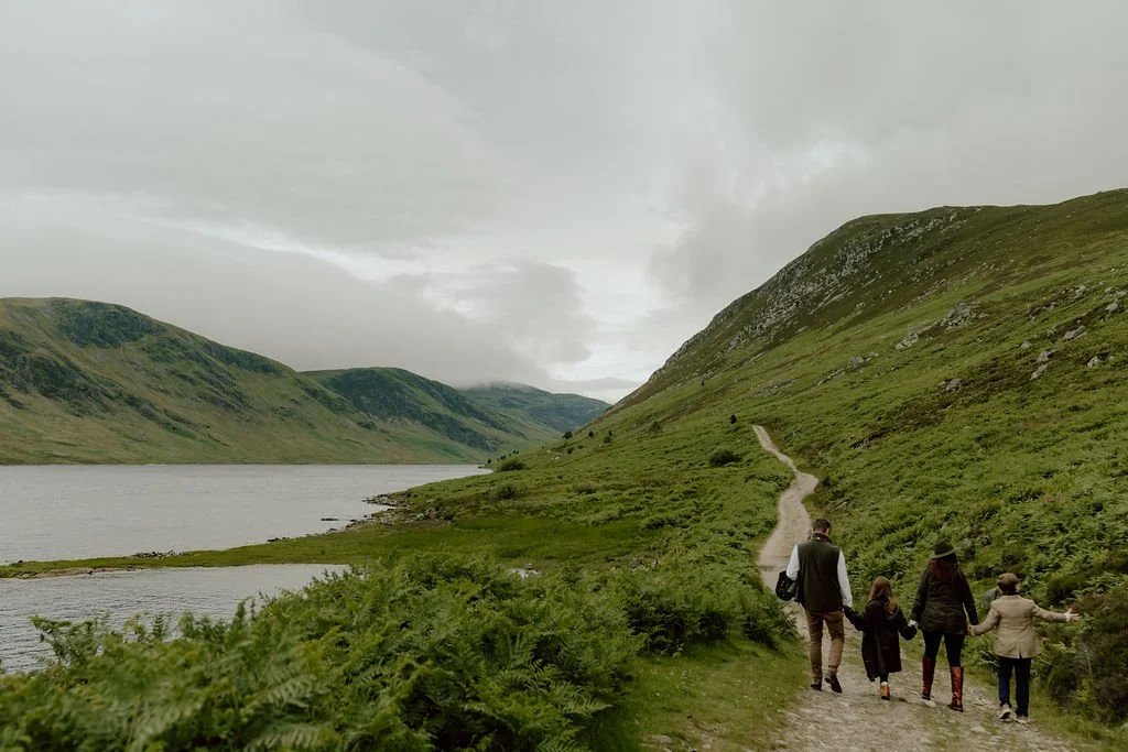 Family walking together along a mountain path beside a Scottish loch turret during their Gleneagles family photography experience captured by Patrice Little Photography