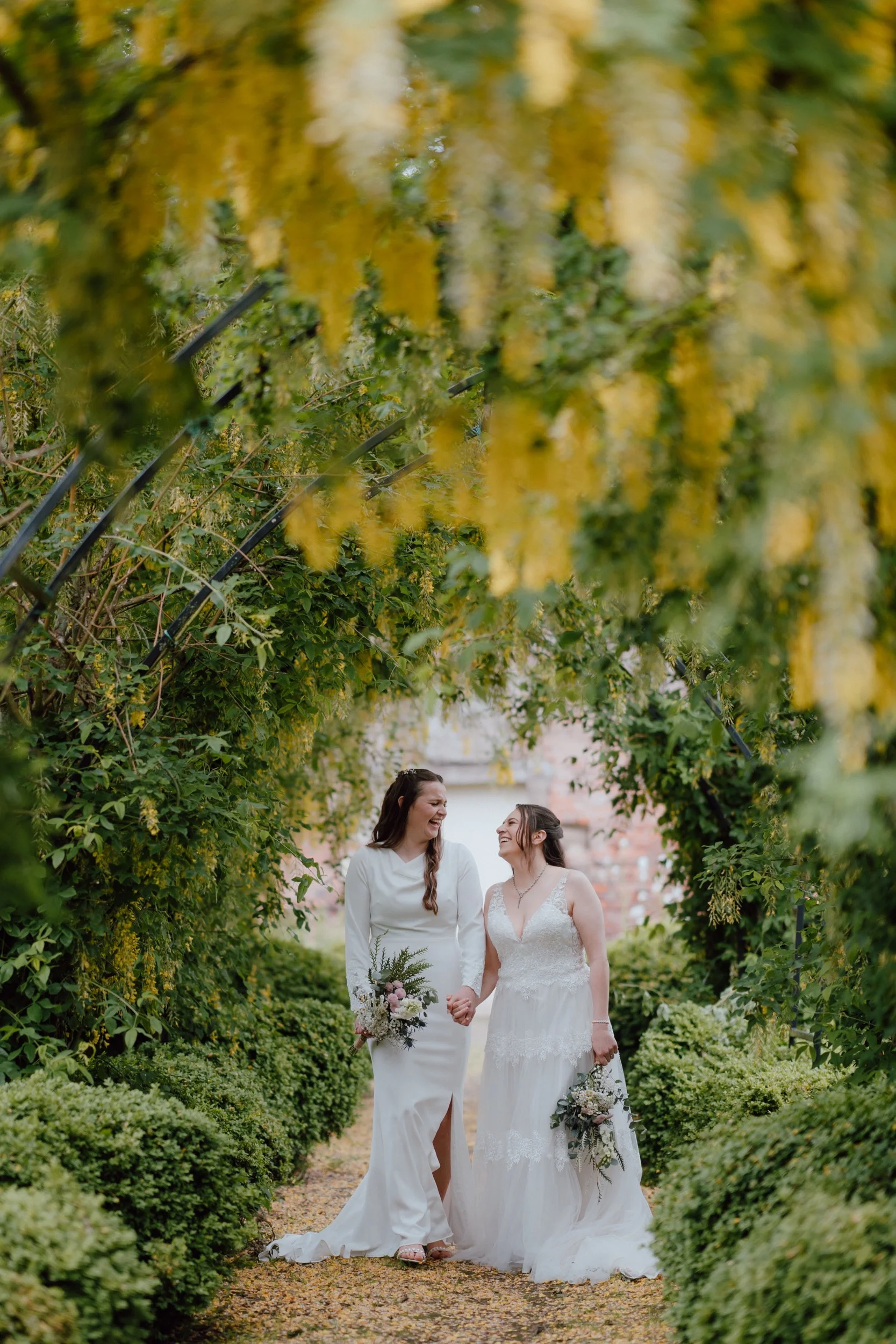 Romantic wedding portrait beneath flowering arches in the gardens of Megginch Castle, Scotland.