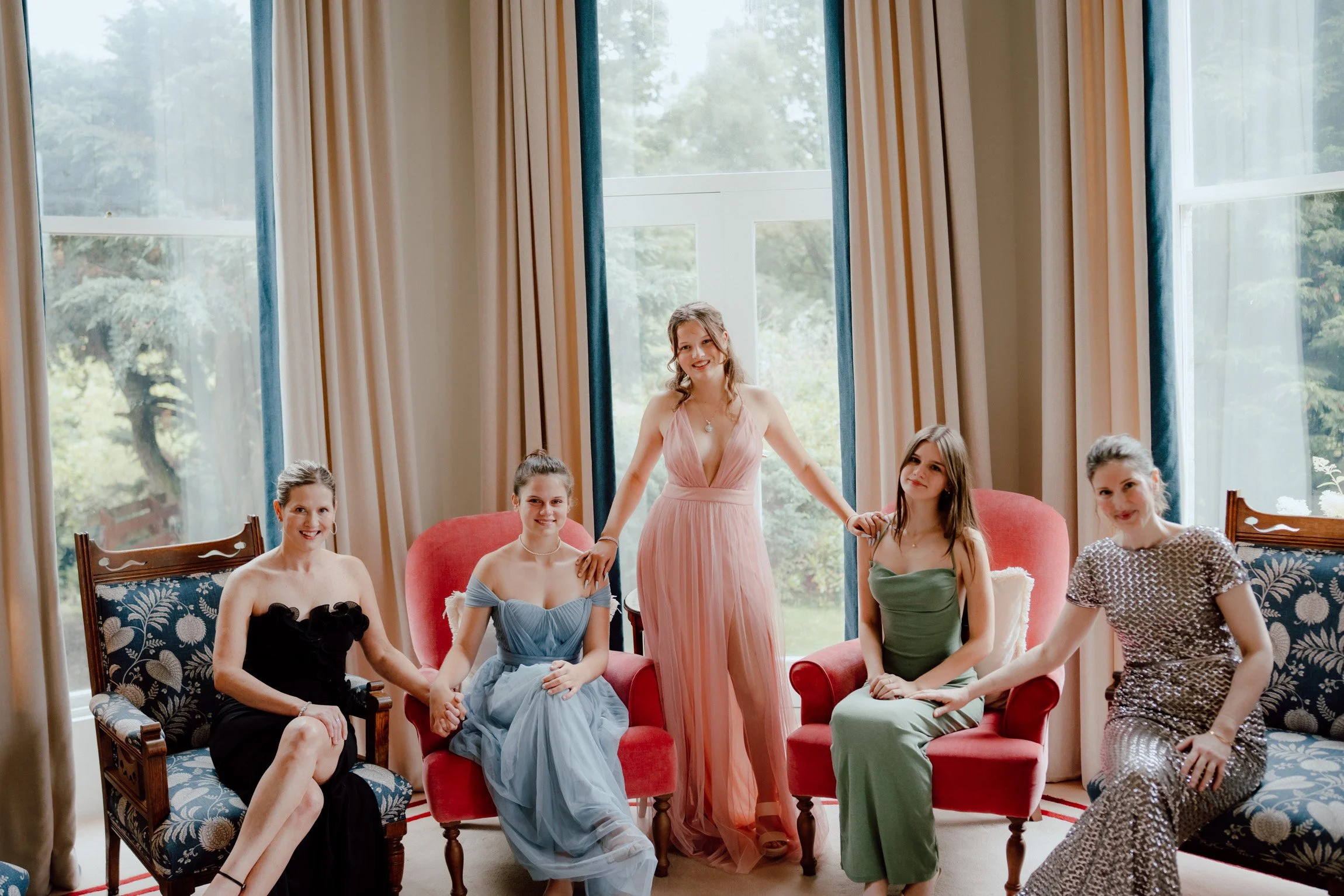 Glamorous family members posing together in an elegant room at Dalnaglar Castle.