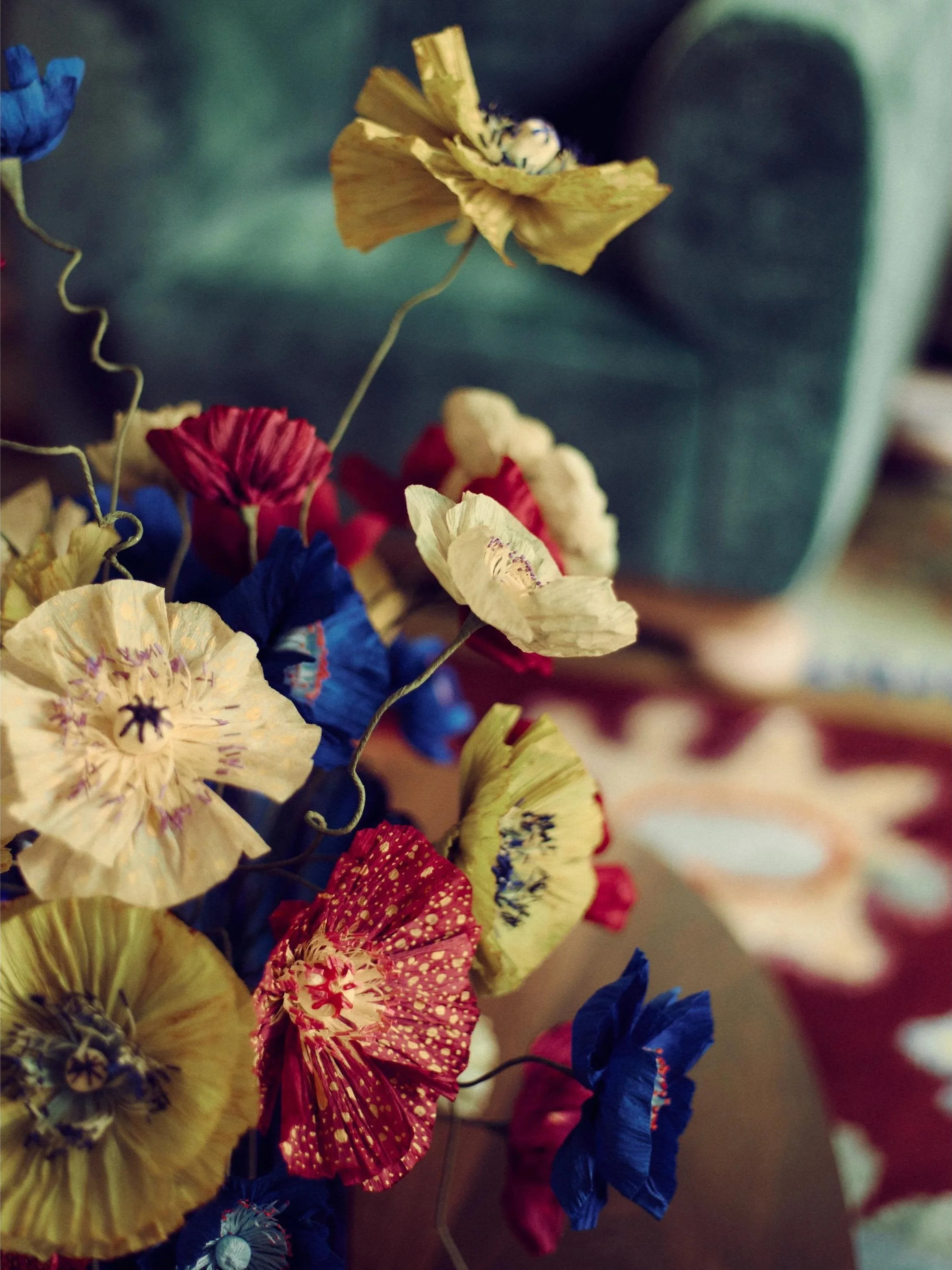 Detailed view of handmade paper poppies in yellow, red, and blue by Emmeli Kimhi for Sister by Studio Ashby at Alcova Milan.