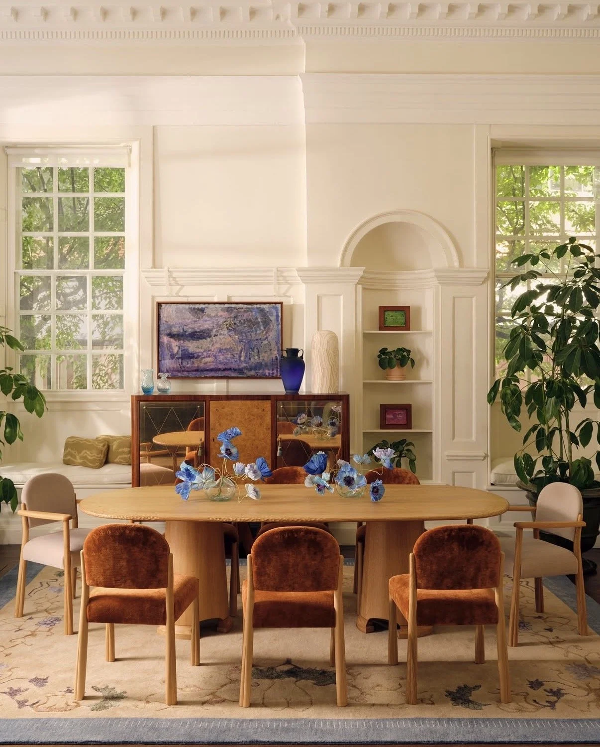 SISTER by Studio Ashby showroom, decorated with blue paper poppies by Emmeli Kimhi on a wooden dining table surrounded by chairs and art.