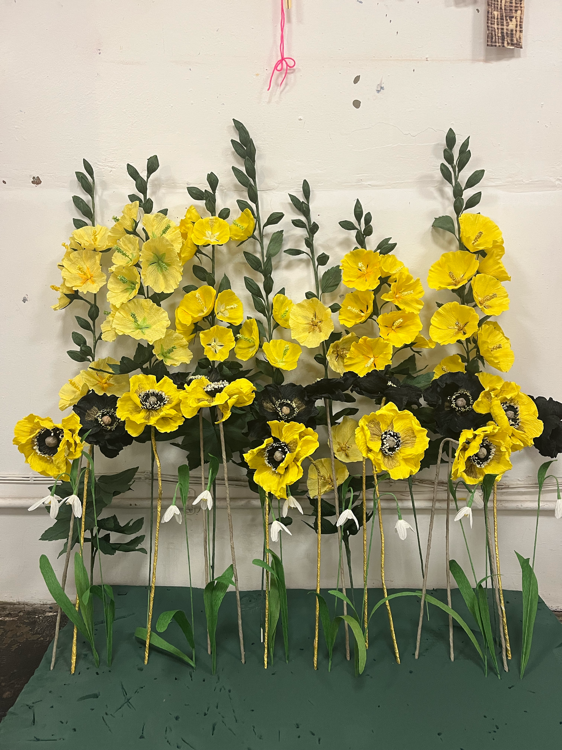 Large yellow and black hand-painted paper poppies with snowdrops by Emmeli Kimhi for Holkham Hall Christmas exhibition
