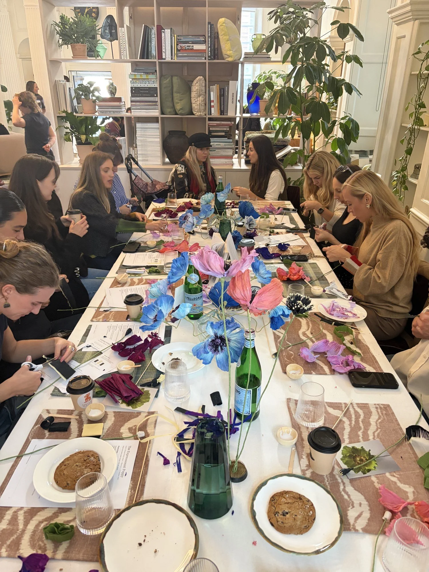 Workshop table at Blewcoat full of guests making paper poppies, with coffee and cookies