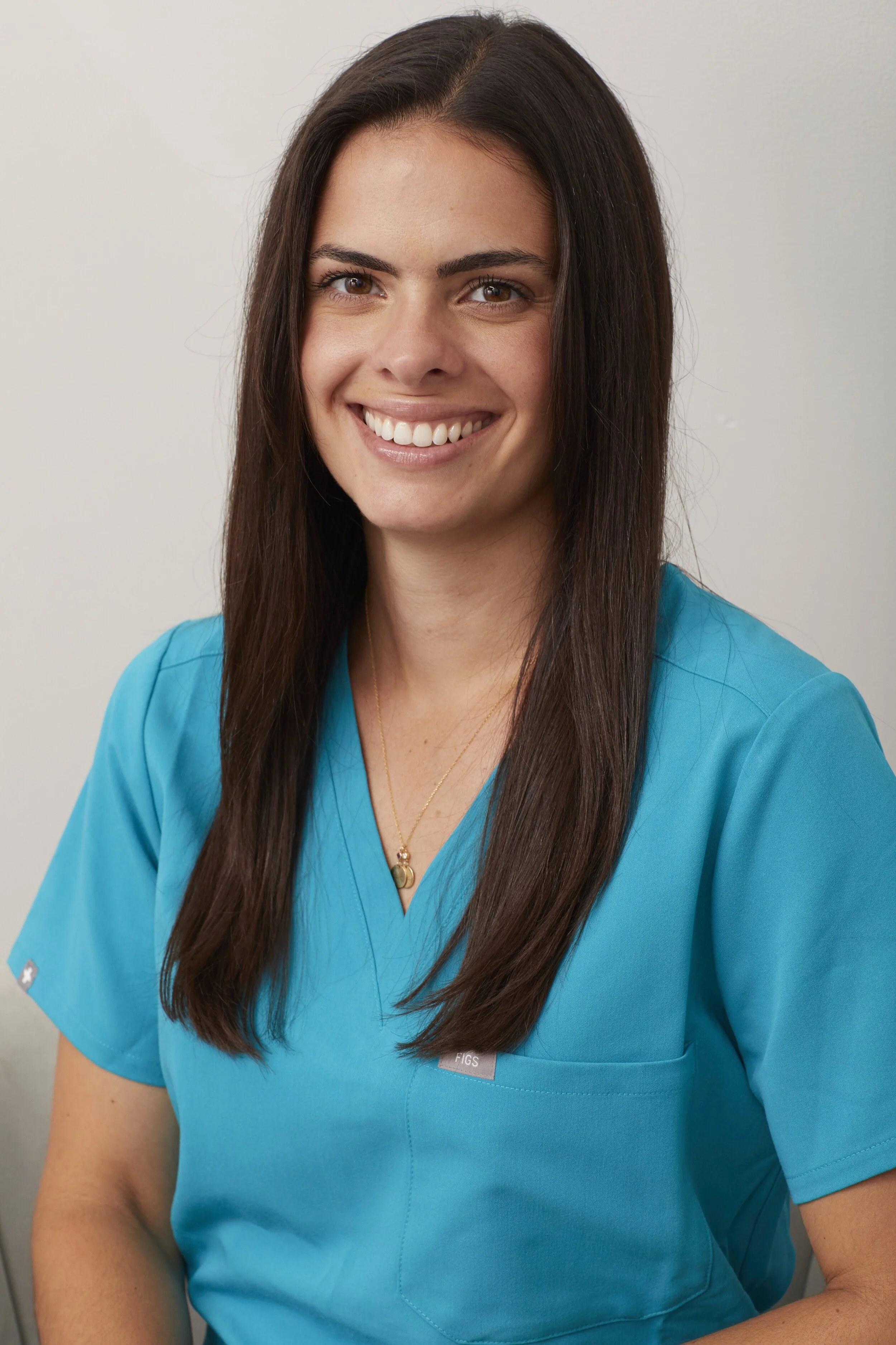 Denturologiste située à St-Bruno-de-Montarville, photo portrait d'elle souriante et parlant de son parcours pour mieux servir les patients de la région dans la clinique dentaire de Dre Roxane Katiya. 