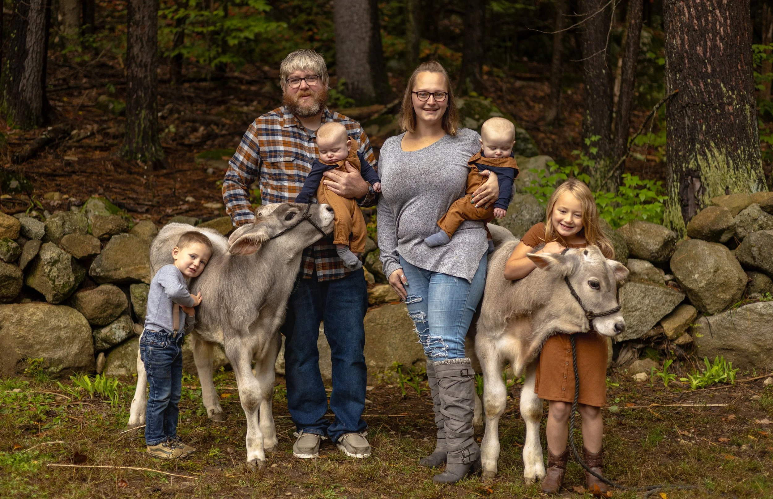 Ashley Norris and her family posing for a family picture with two of their farm animals
